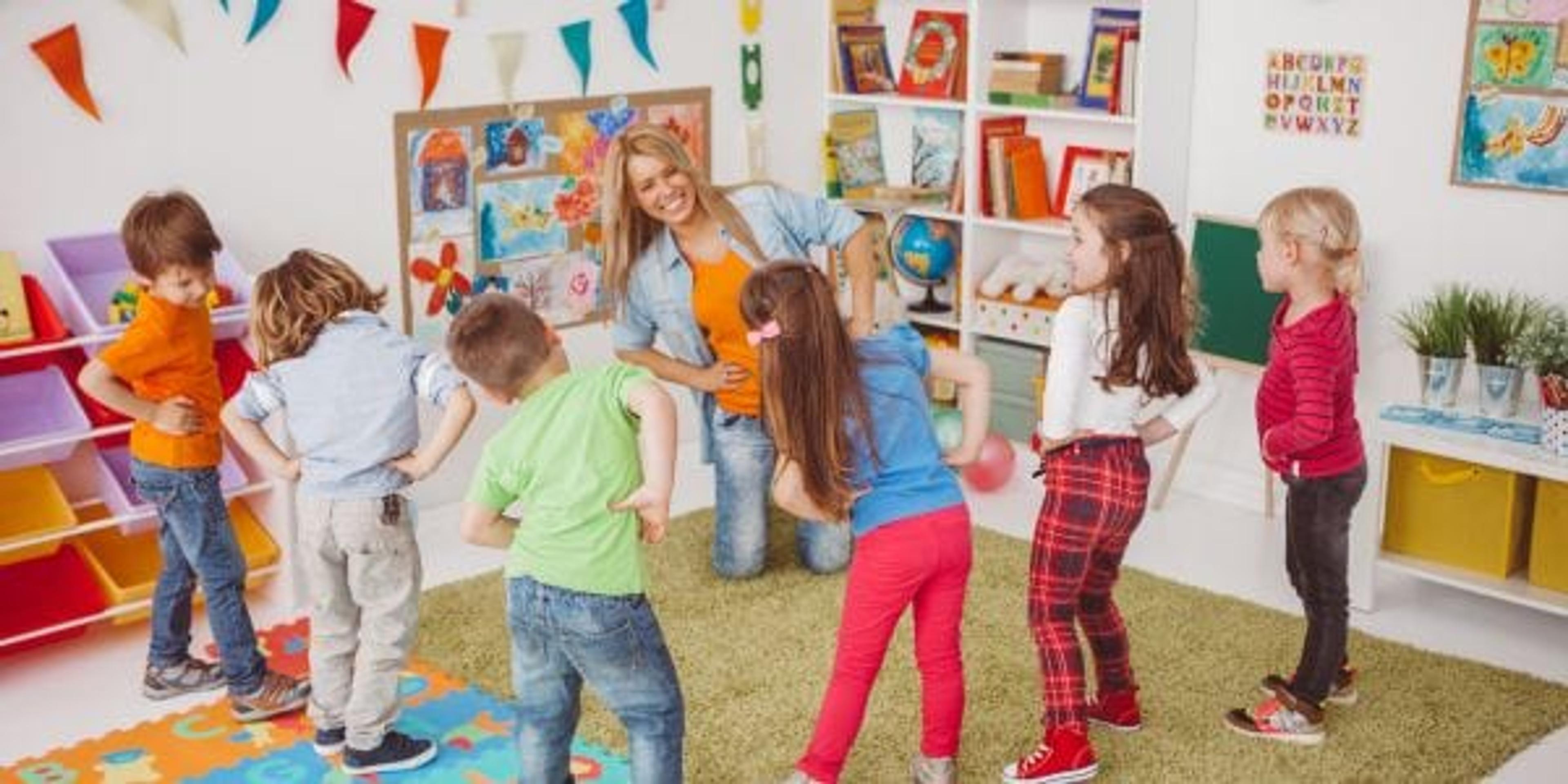 Kids in kindergarden doing exercises with their teacher