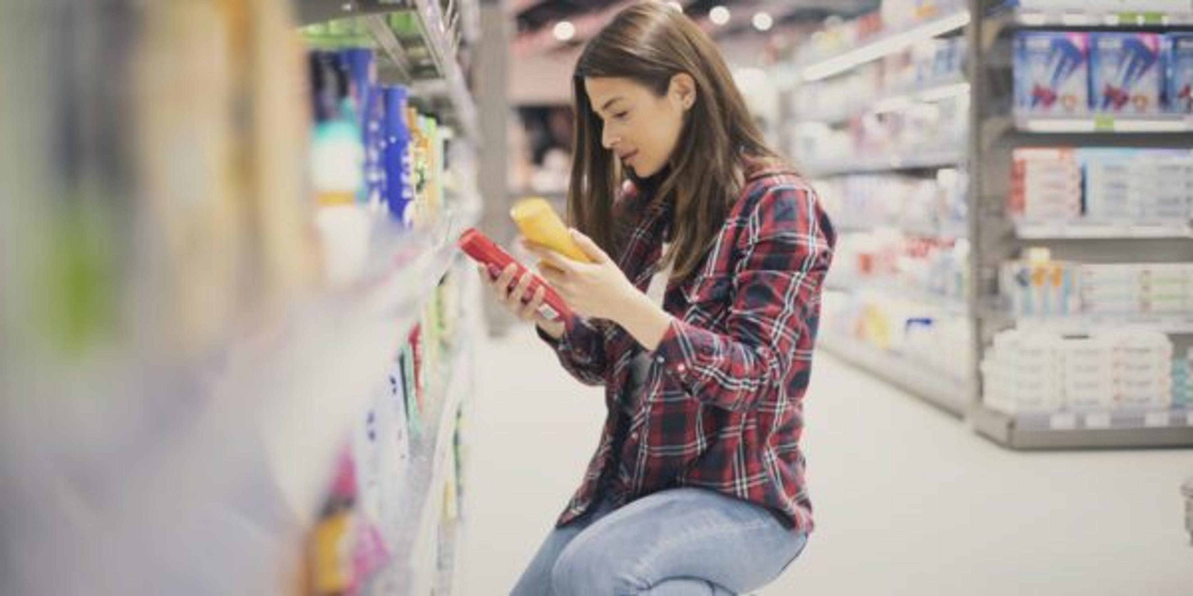A woman examines sunscreen brands at the store.