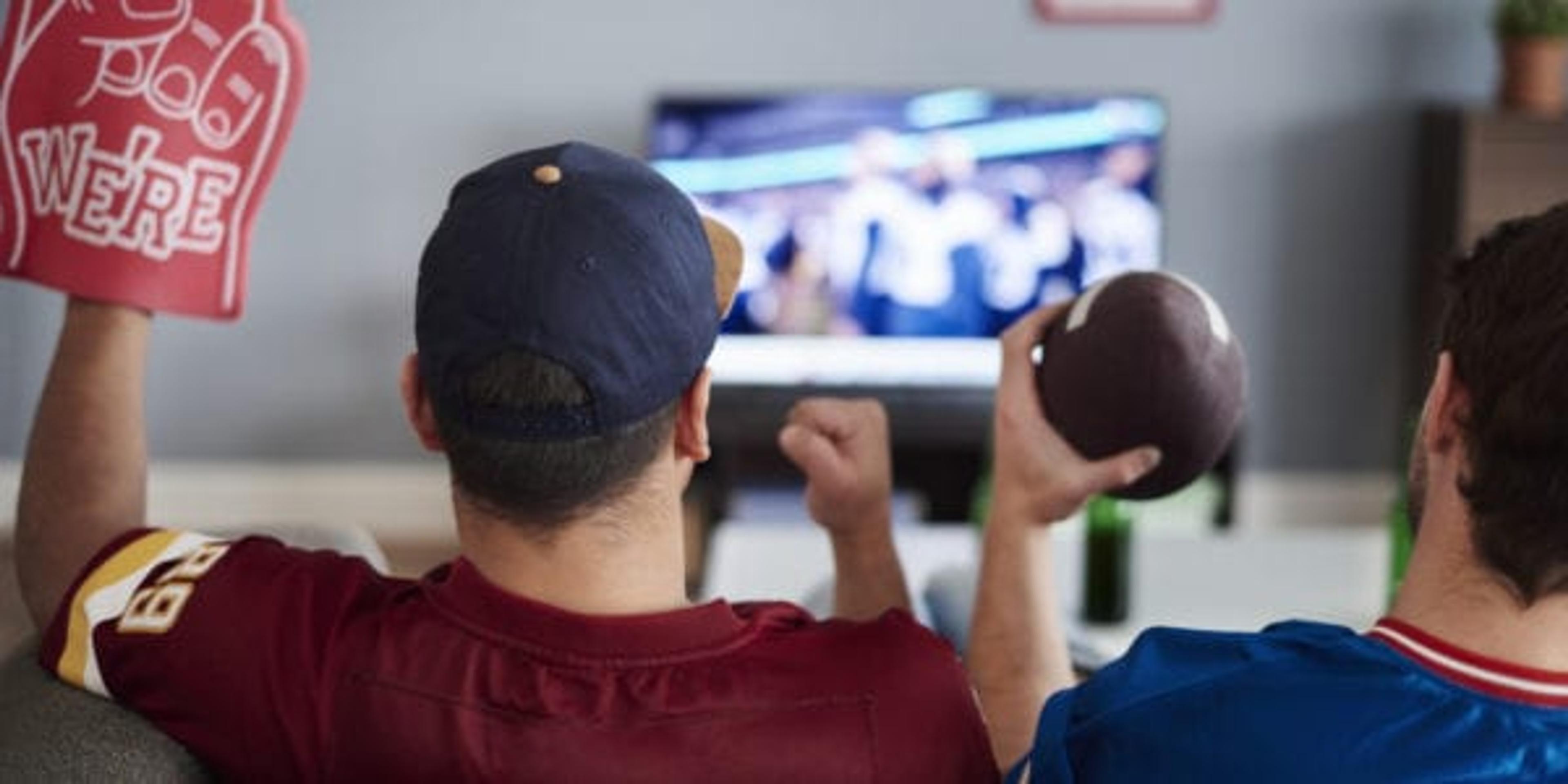 Two men with foam hand and baseball equipment