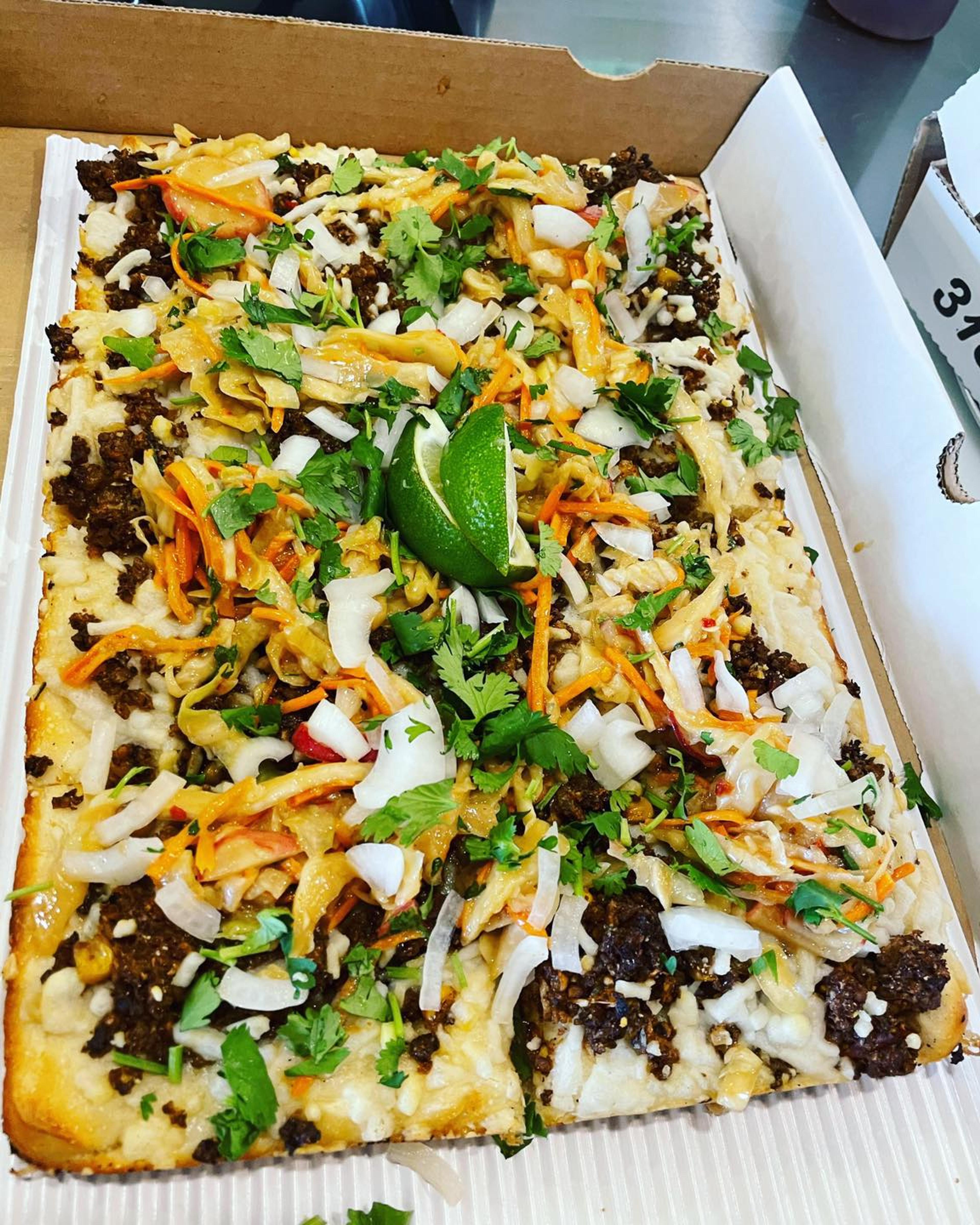 "Taco’s Modern Life:" Garlic oil, cauliflower-walnut mock chorizo, roasted corn, Follow Your Heart vegan mozz, topped with white onion, radish slaw, fresh cilantro and lime wedge.