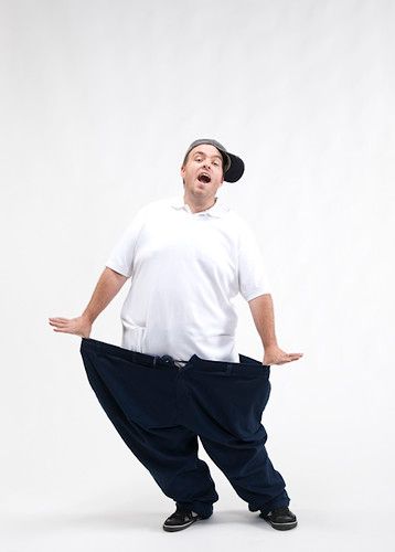 overweight man in tank top holding oversize pants after weight loss on  white Stock Photo | Adobe Stock