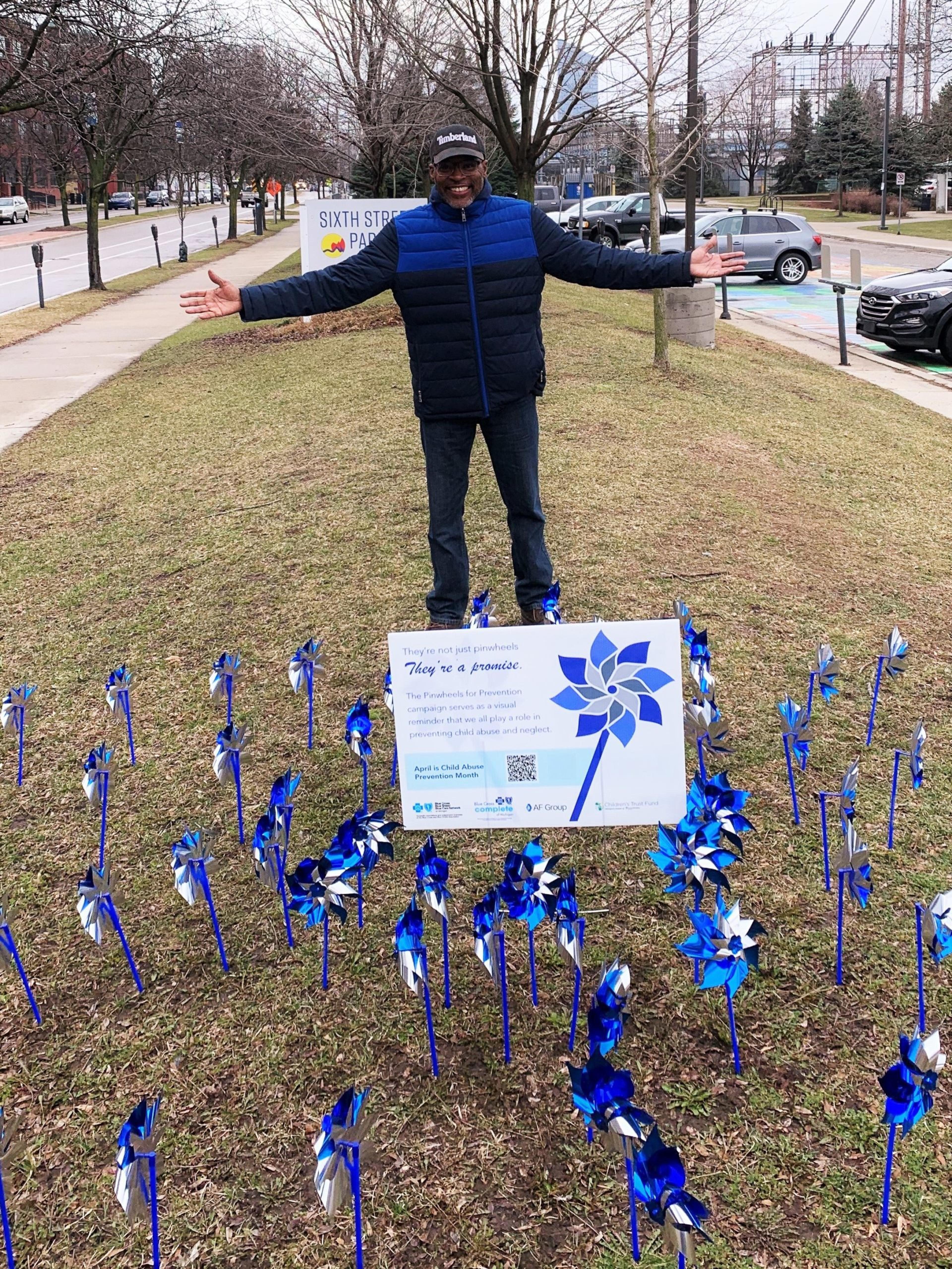 Man stands next to pinwheel garden