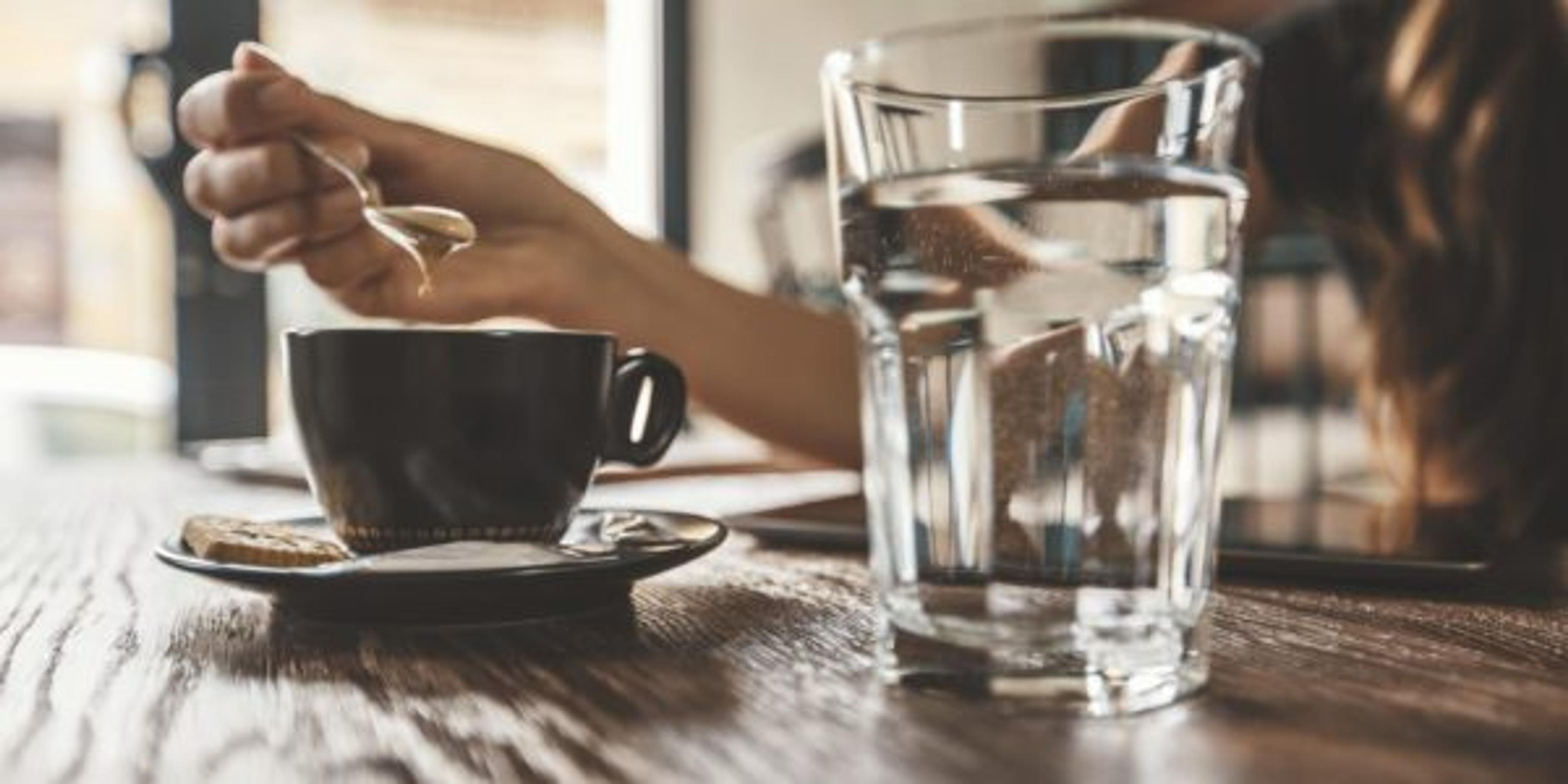 Unrecognizable woman is having coffee in a cafe bar.