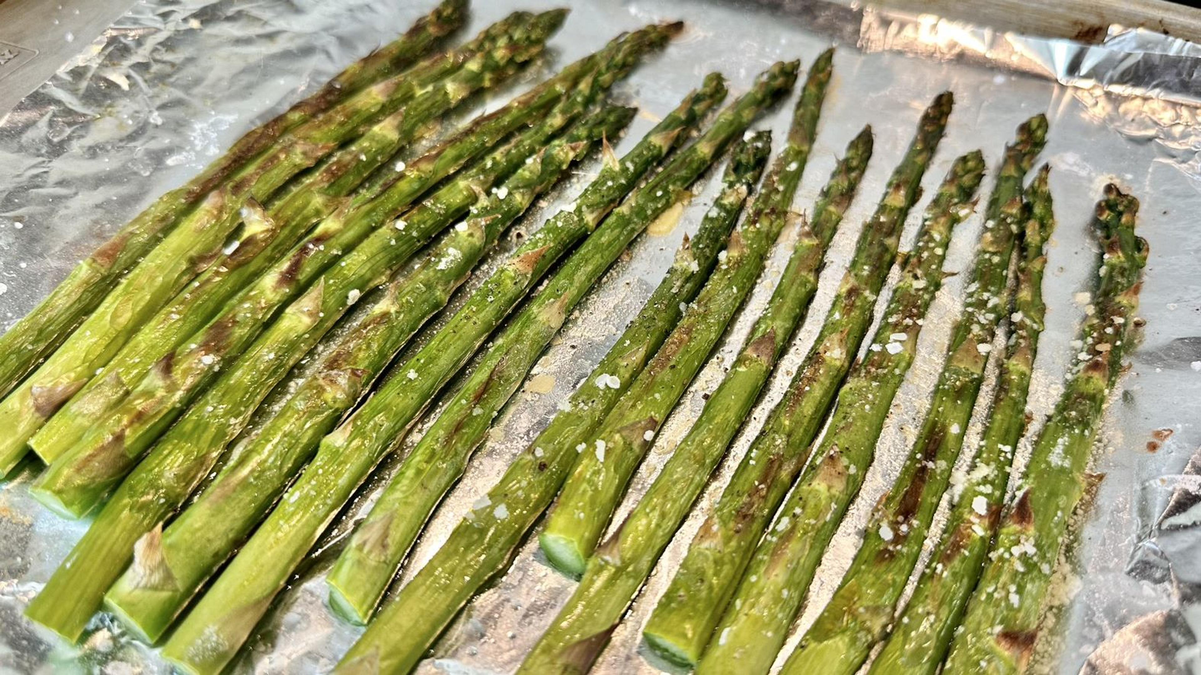 Turn the broiler on high. Toss Asparagus in olive oil, salt and pepper. Do not add lemon juice as it will taste best fresh after roasting. Place on the baking sheet. Roast under top broiler for 5-7 minutes depending on the thickness of the asparagus. Very thin asparagus will only need about 5 minutes. The asparagus should have a nice brown color on top with a few charred bits.