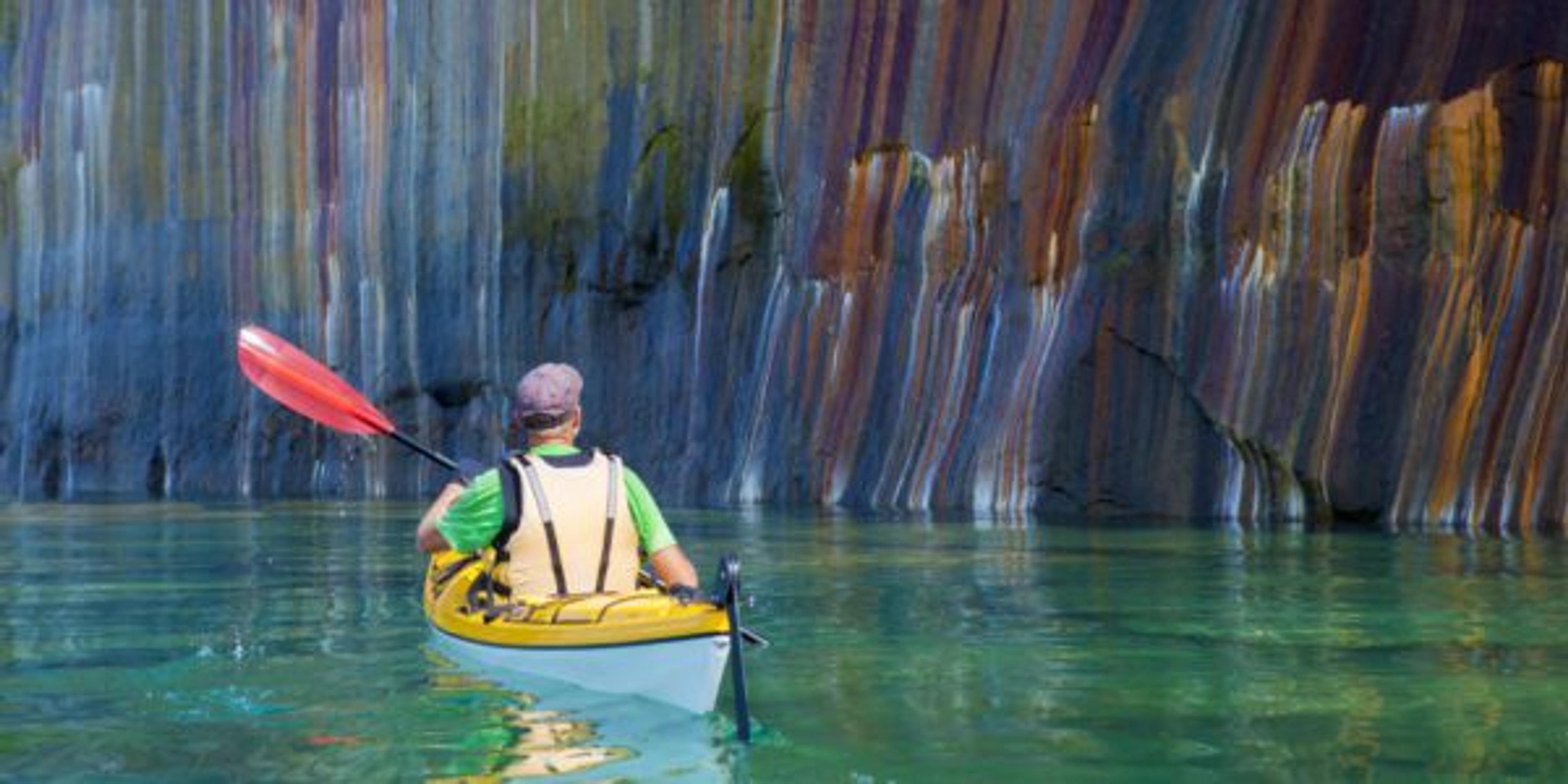 Sea kayaker viewing the multi-colored cliffs at the Pictured Rocks National Lakeshore on Lake Superior in Michigan’s Upper Peninsula