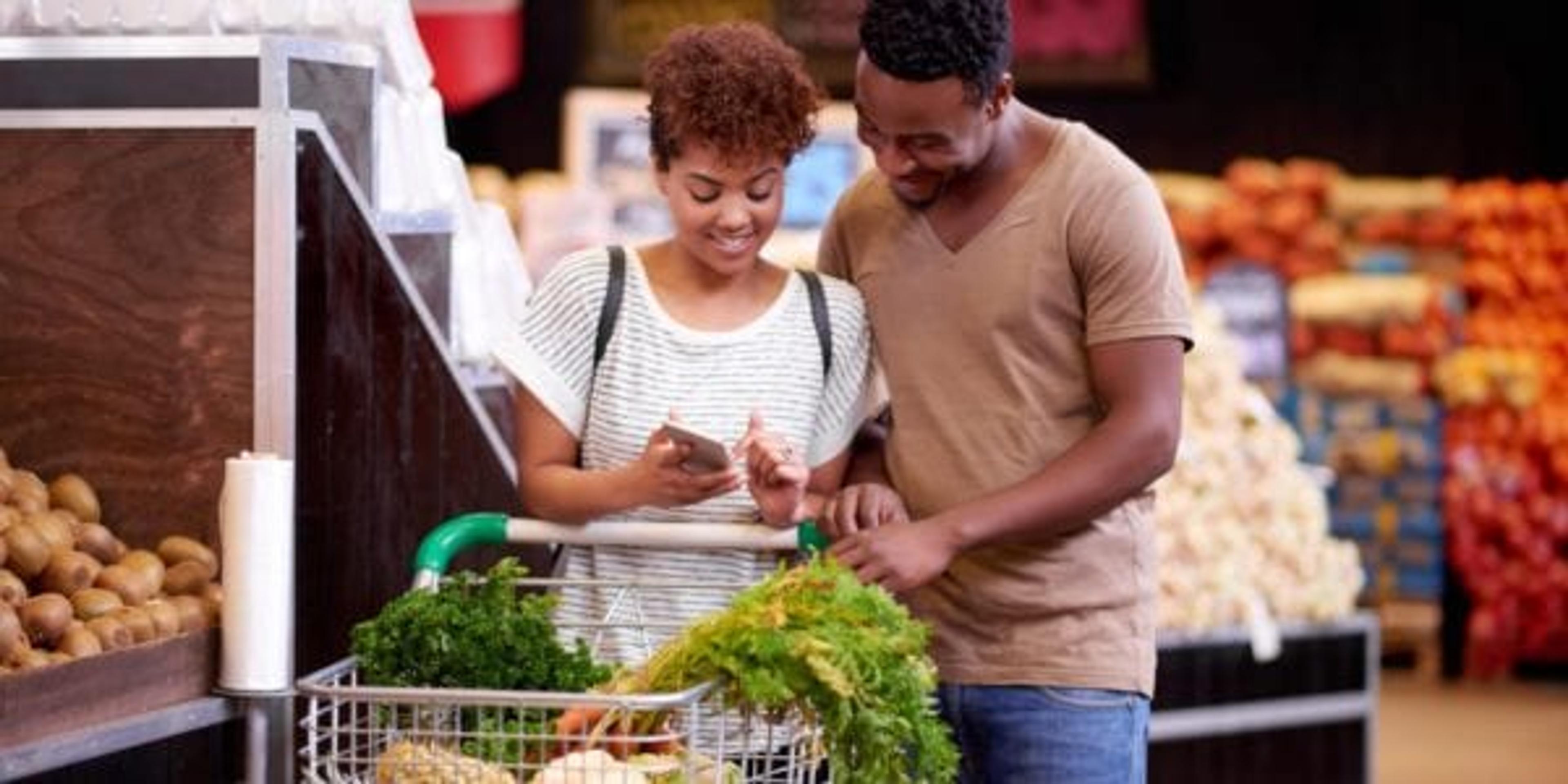 Shot of a young couple looking at a list while shopping in a grocery store