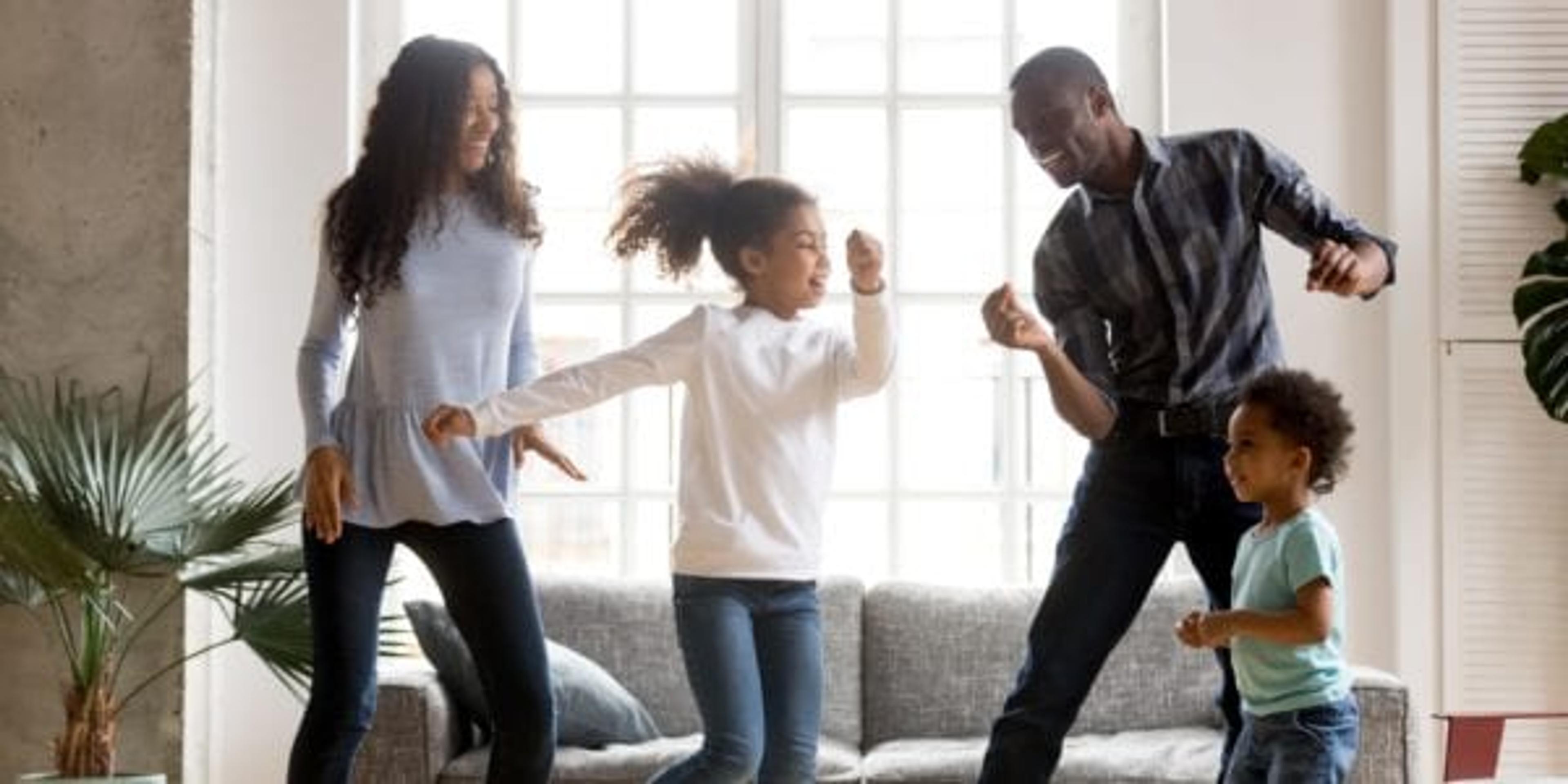 Happy African American family dancing together indoors