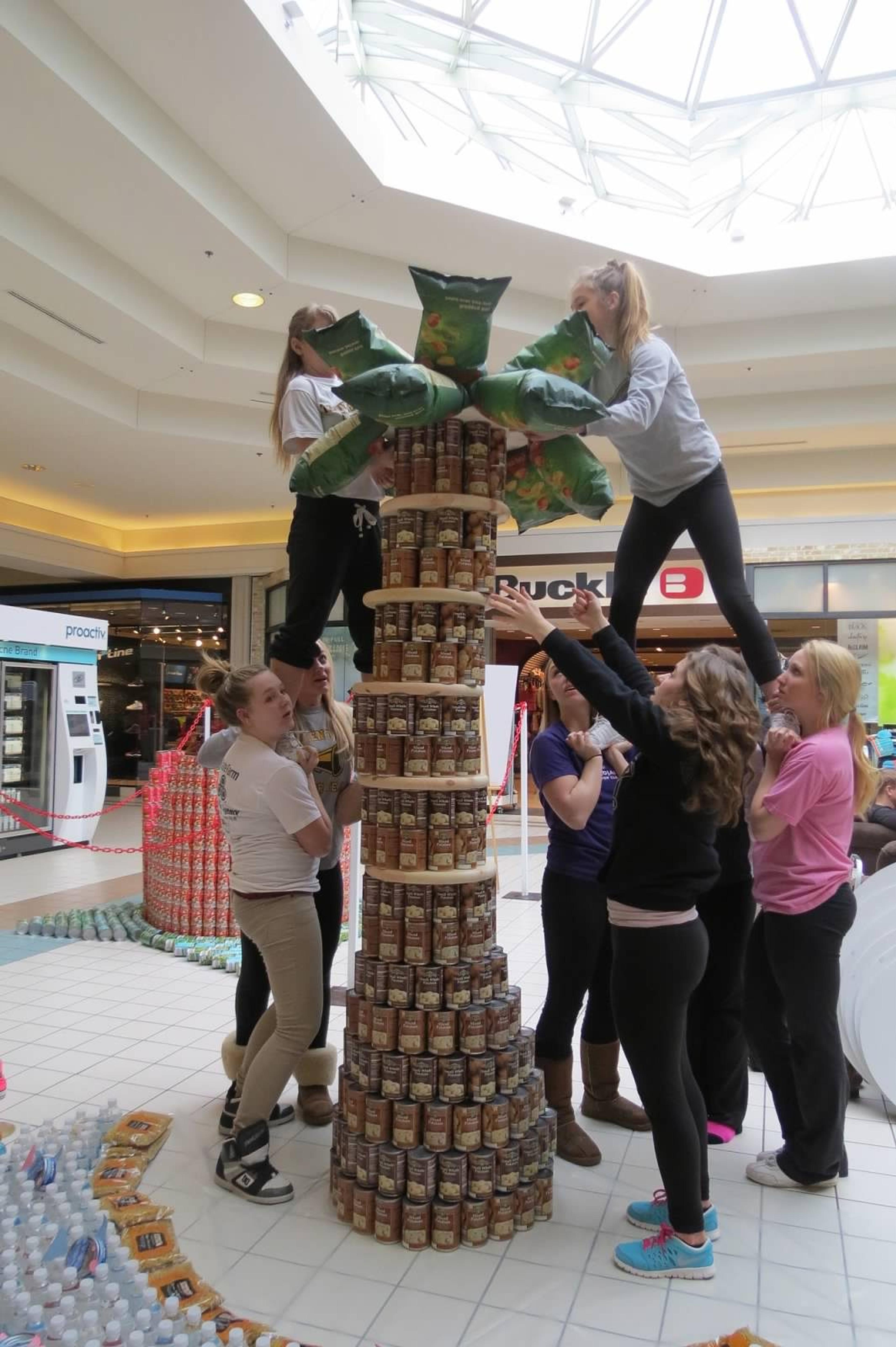 Traverse City Central High School cheerleaders work on their Canstruction exhibit from last year. They're building a castle at this year's event.
