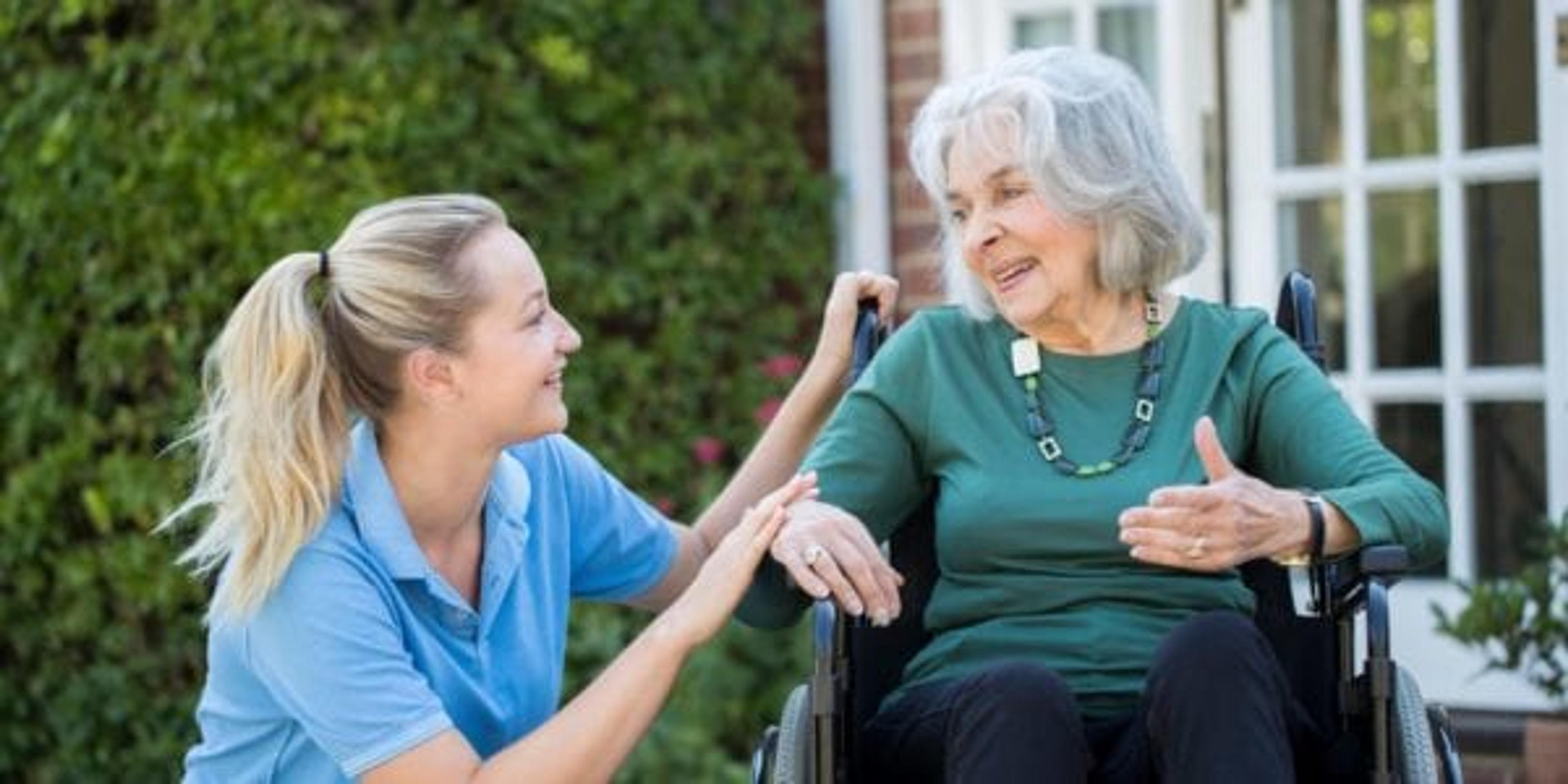 daughter talking to mother in wheelchair