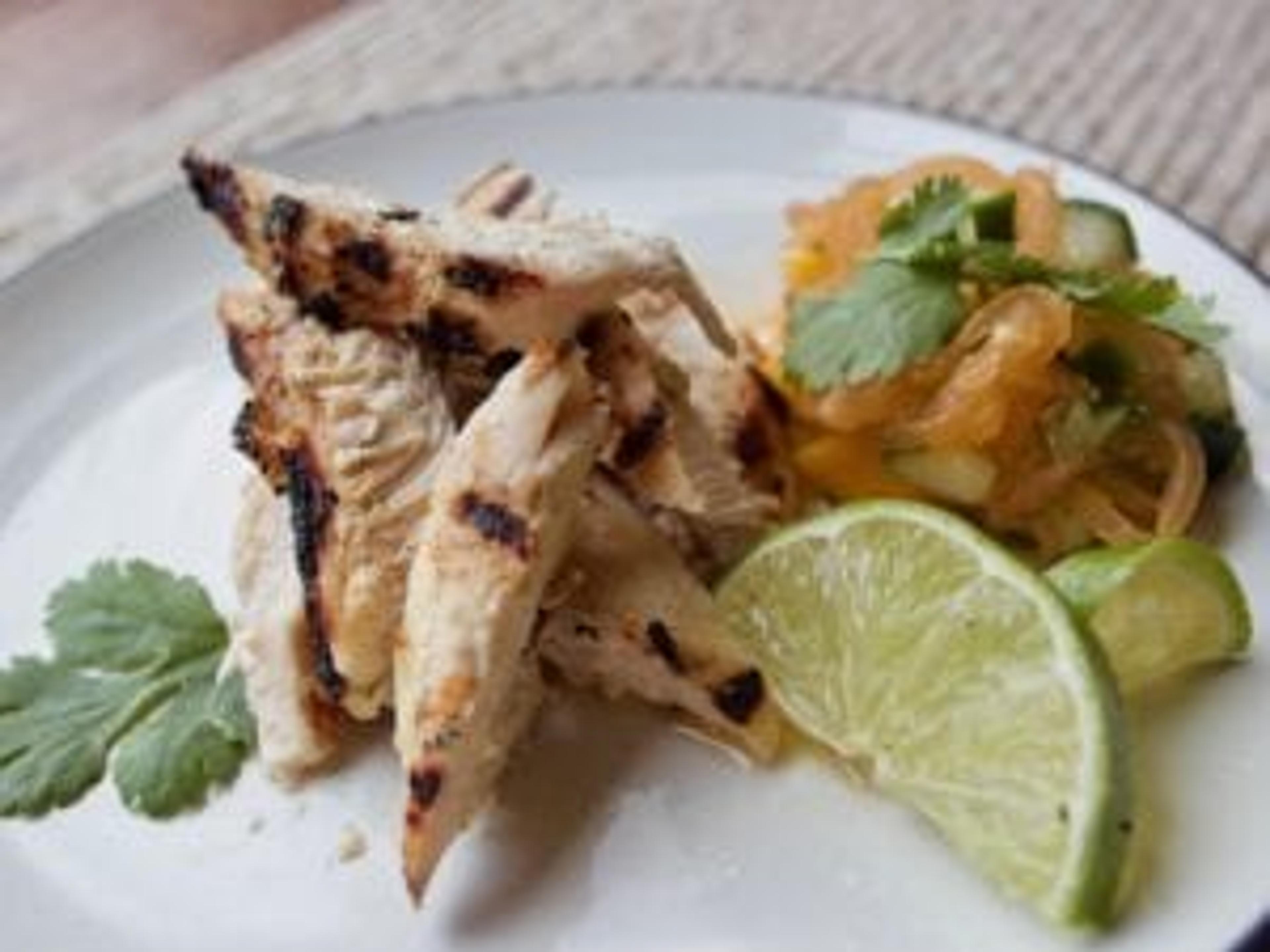 Grilled chicken on a plate with slaw.