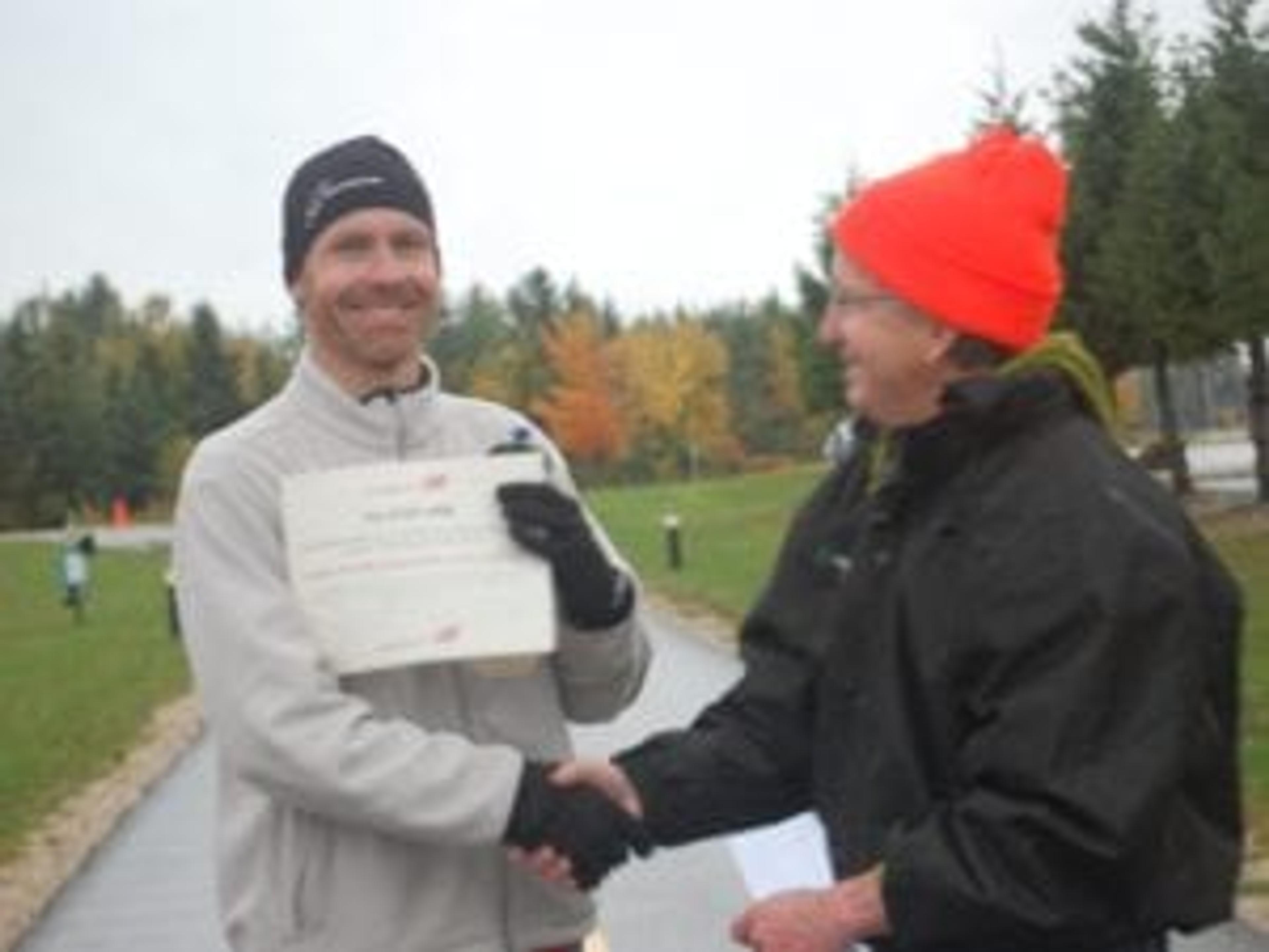 Roger Bonga receiving his winner's certificate from Jeff Winegard in 2012.