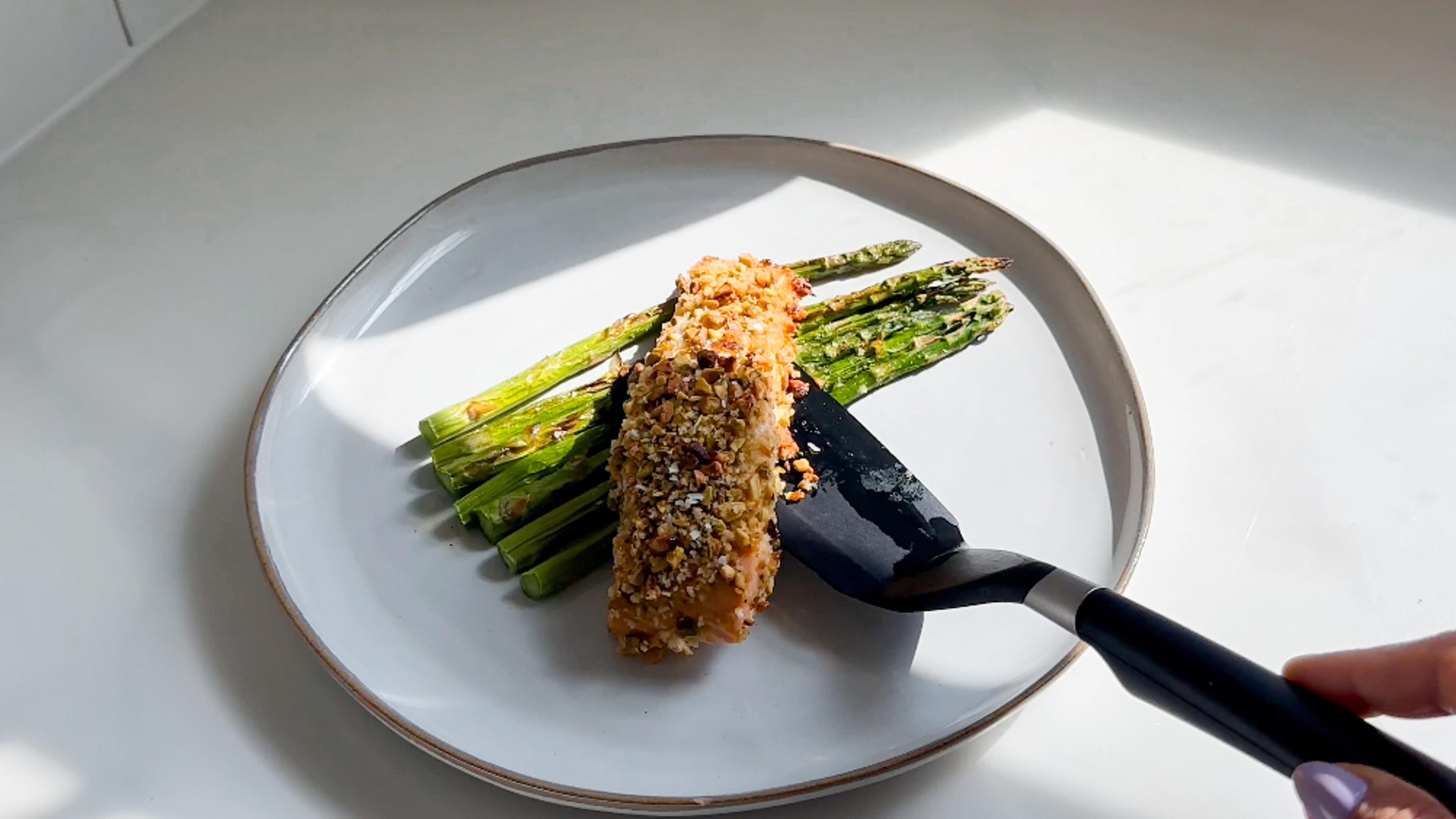 Serve salmon with asparagus on a plate. Top with lemon juice and grated parmesan.