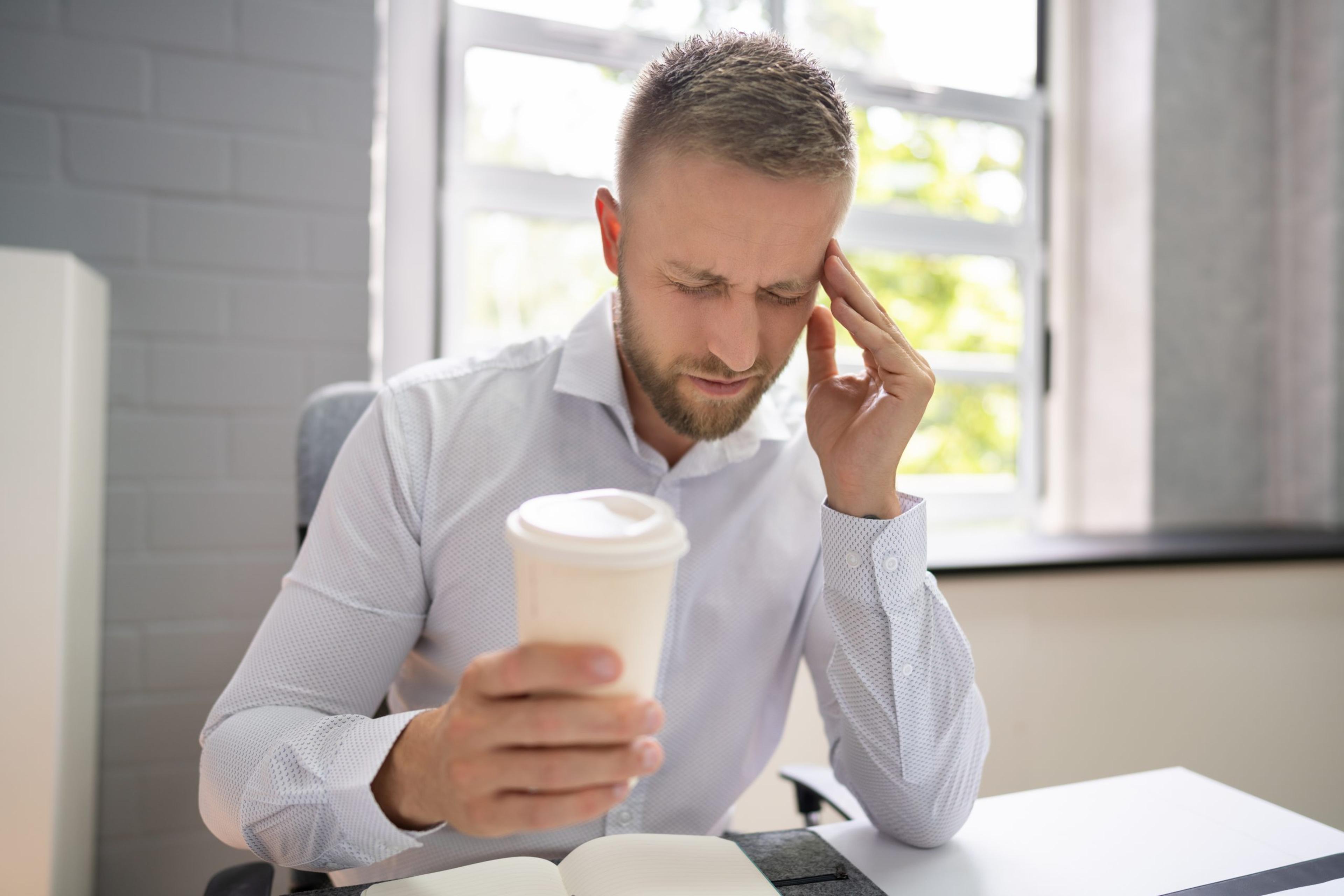 Person Holding Coffee Cup Having Headache