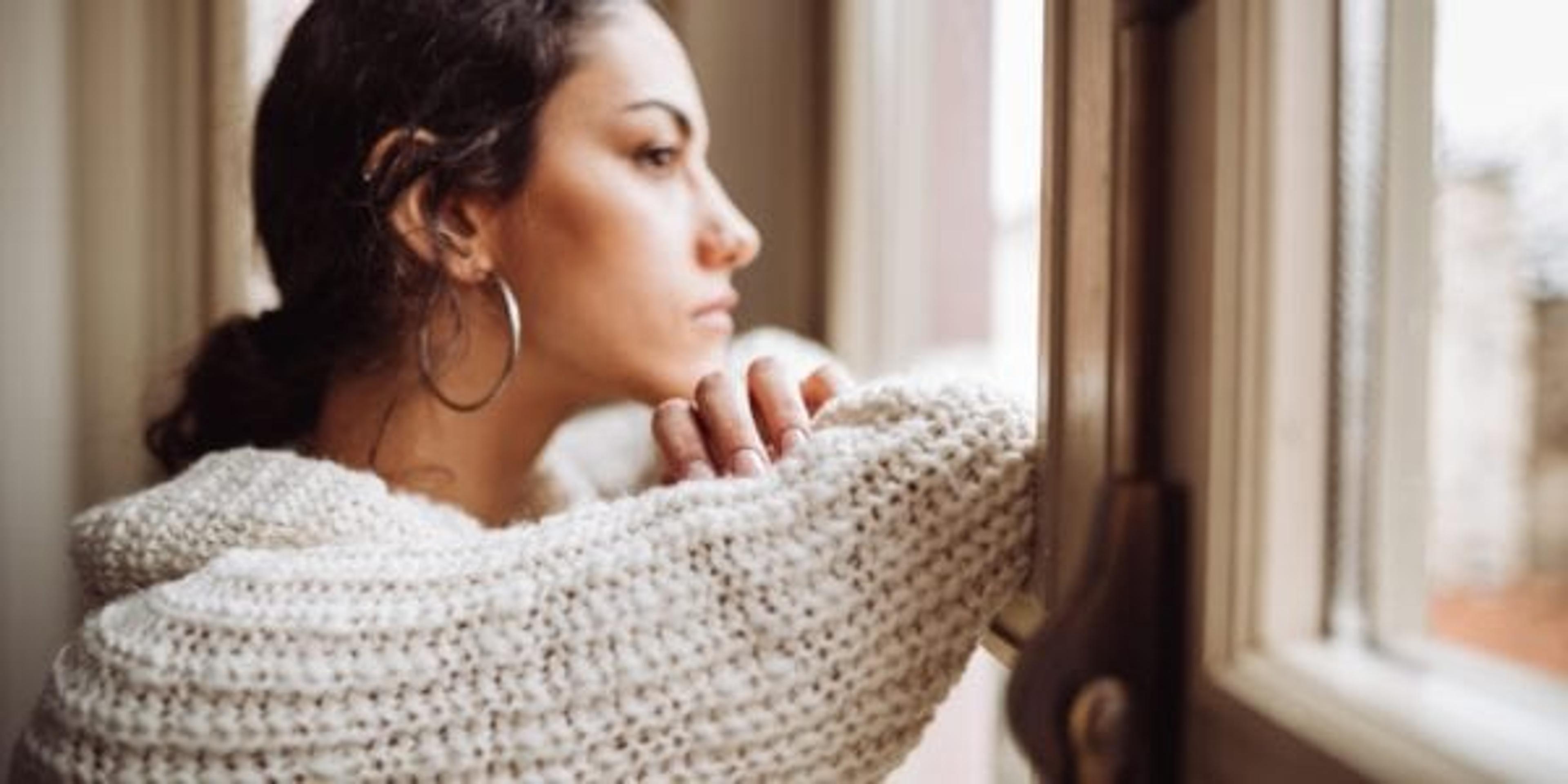 pensive woman in front of the window