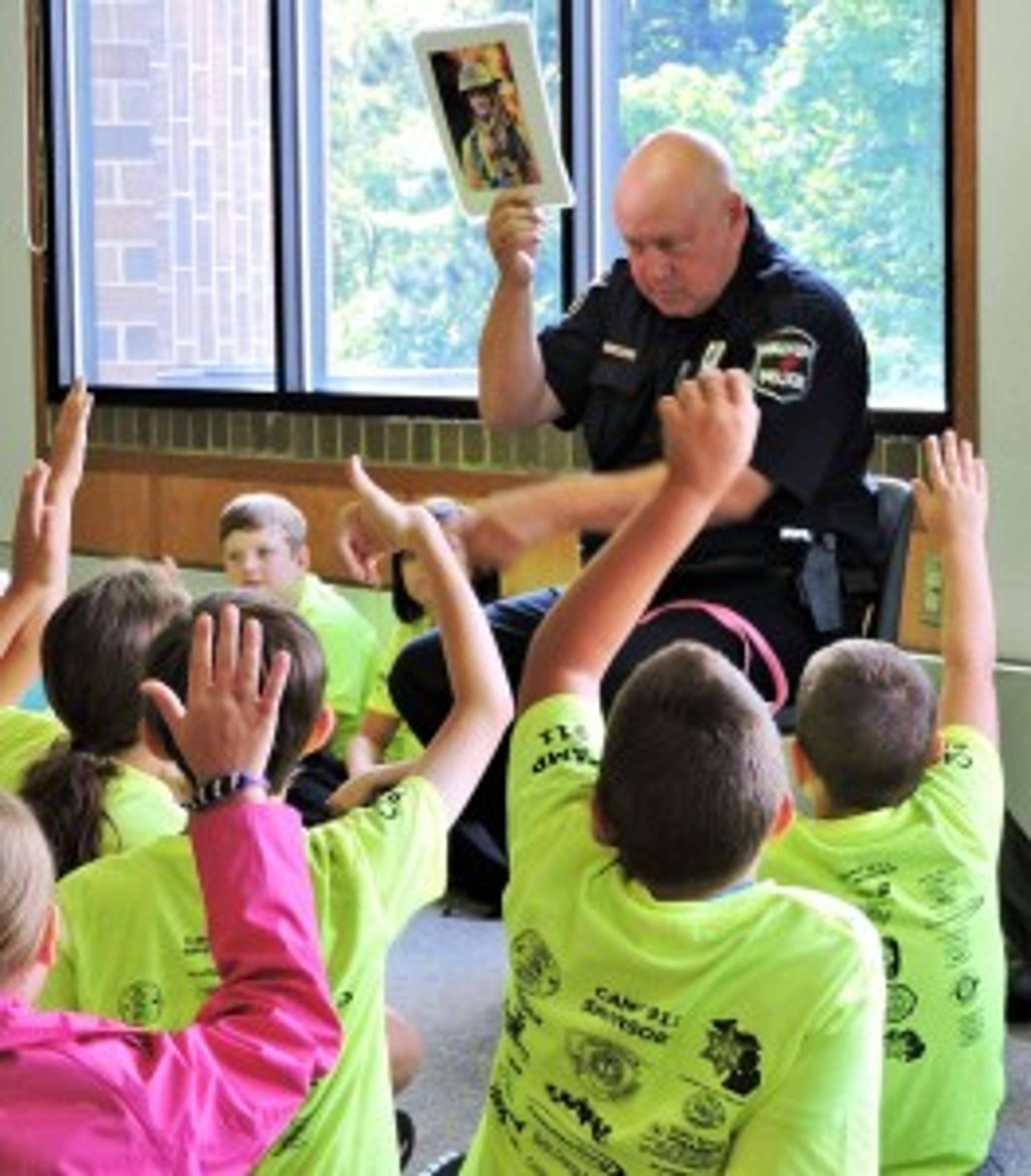 Walker Police Department Officer Gil Redzinski quizzes kids at a recent Life EMS Ambulance Camp 911 event about strangers. 