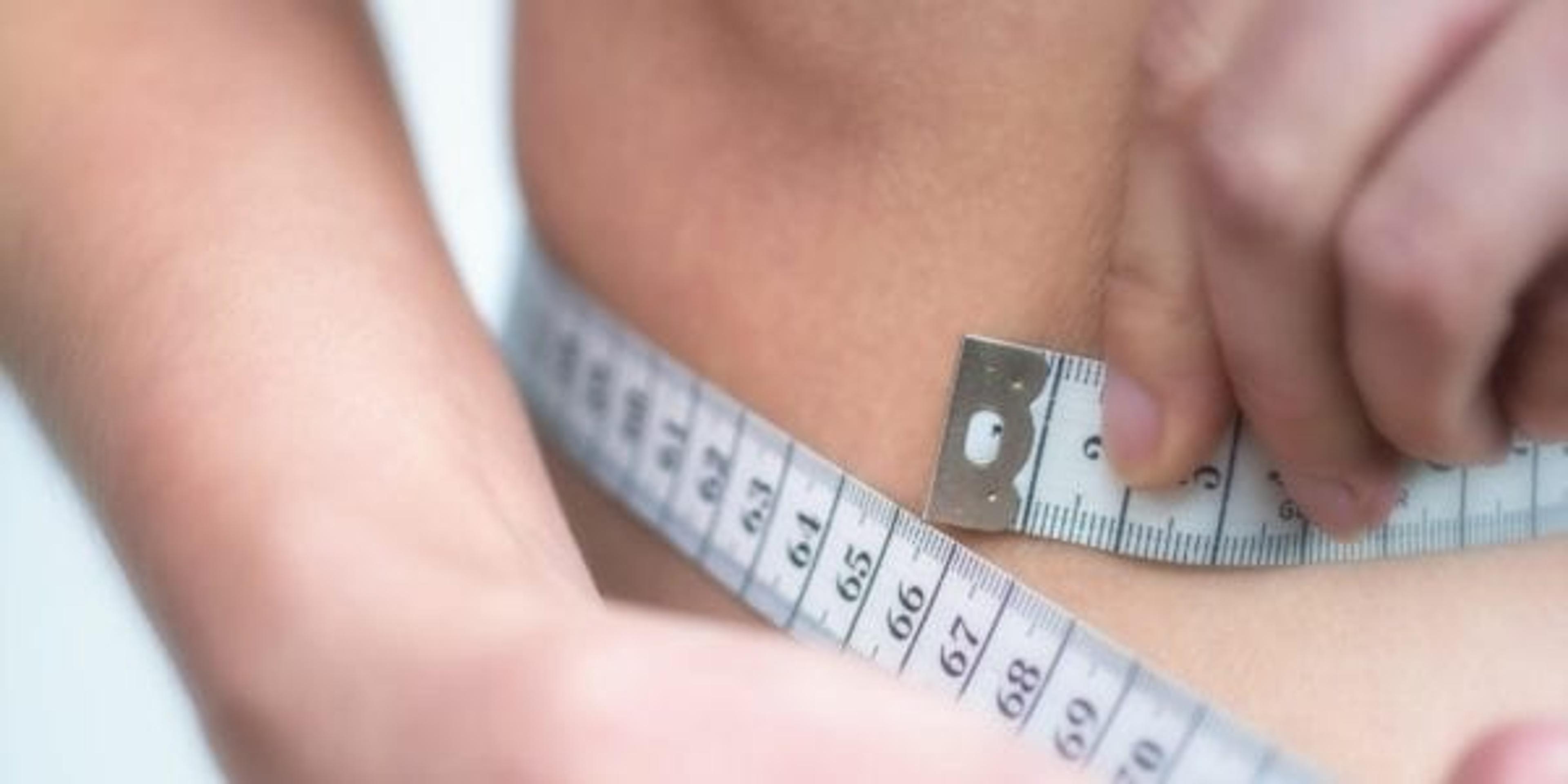 Person measuring their waist