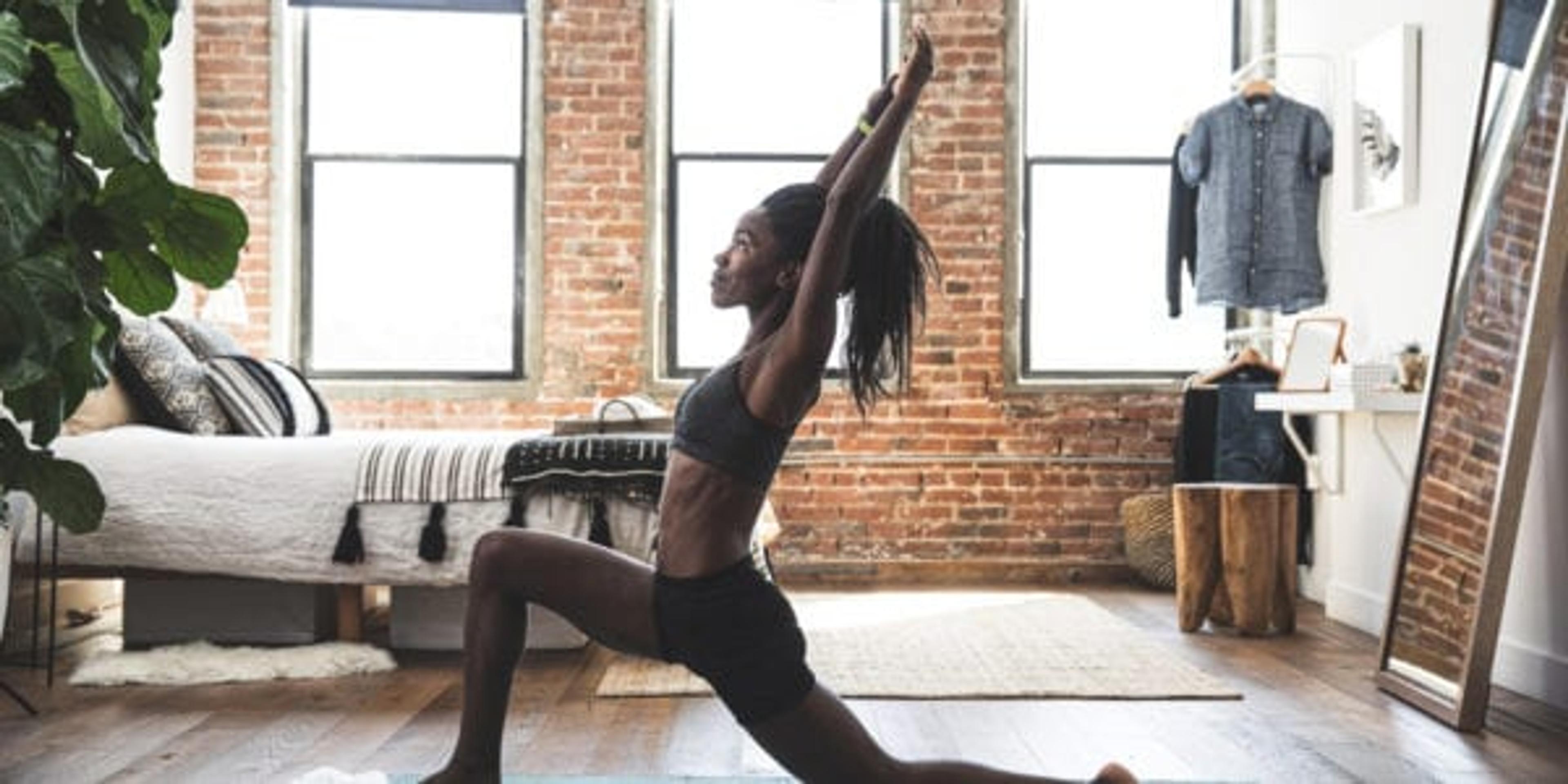 Young sporty woman practicing yoga at home