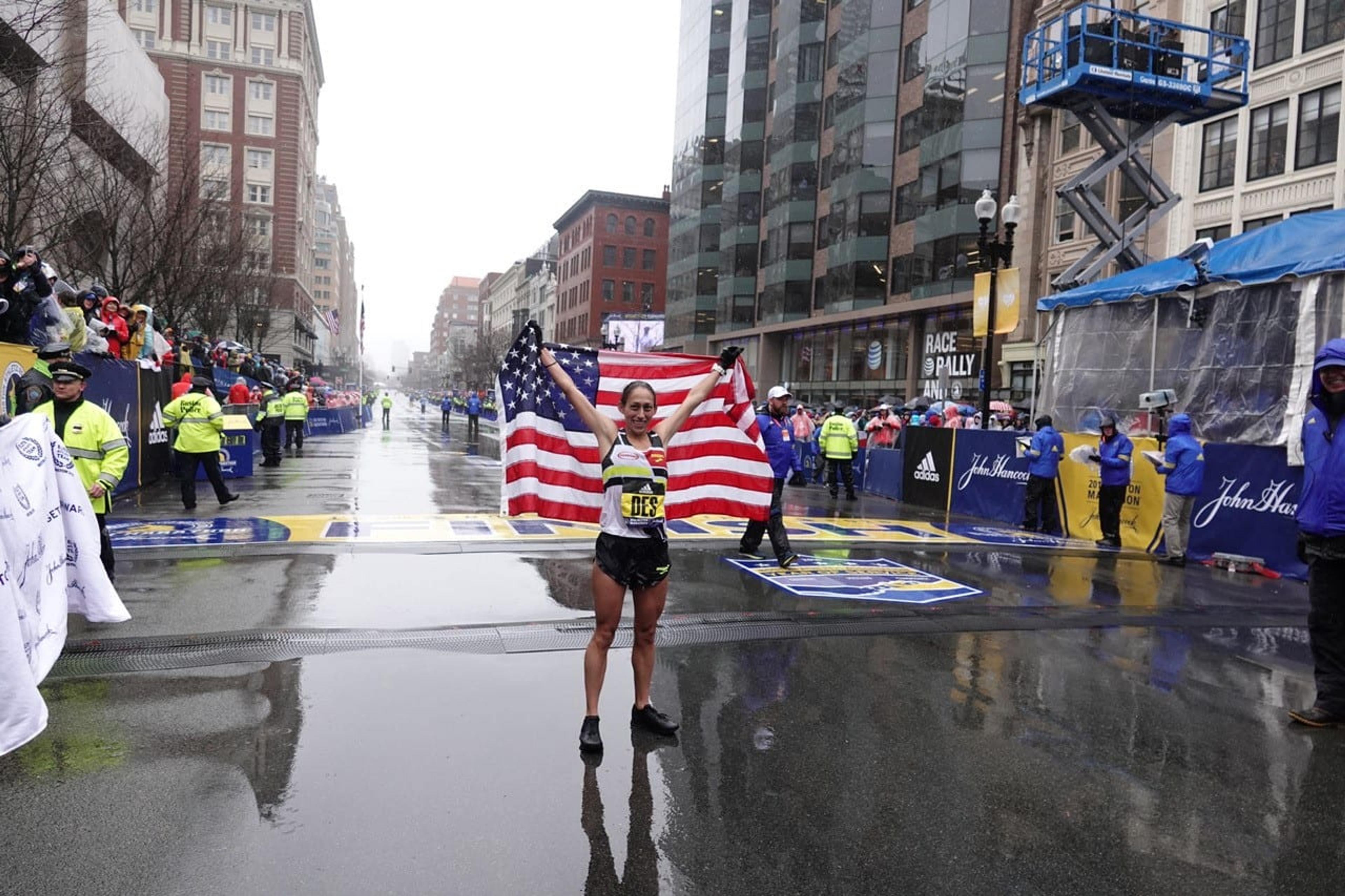 Photo of Desiree Linden holding up the American flag after winning the 2018 Boston Marathon.