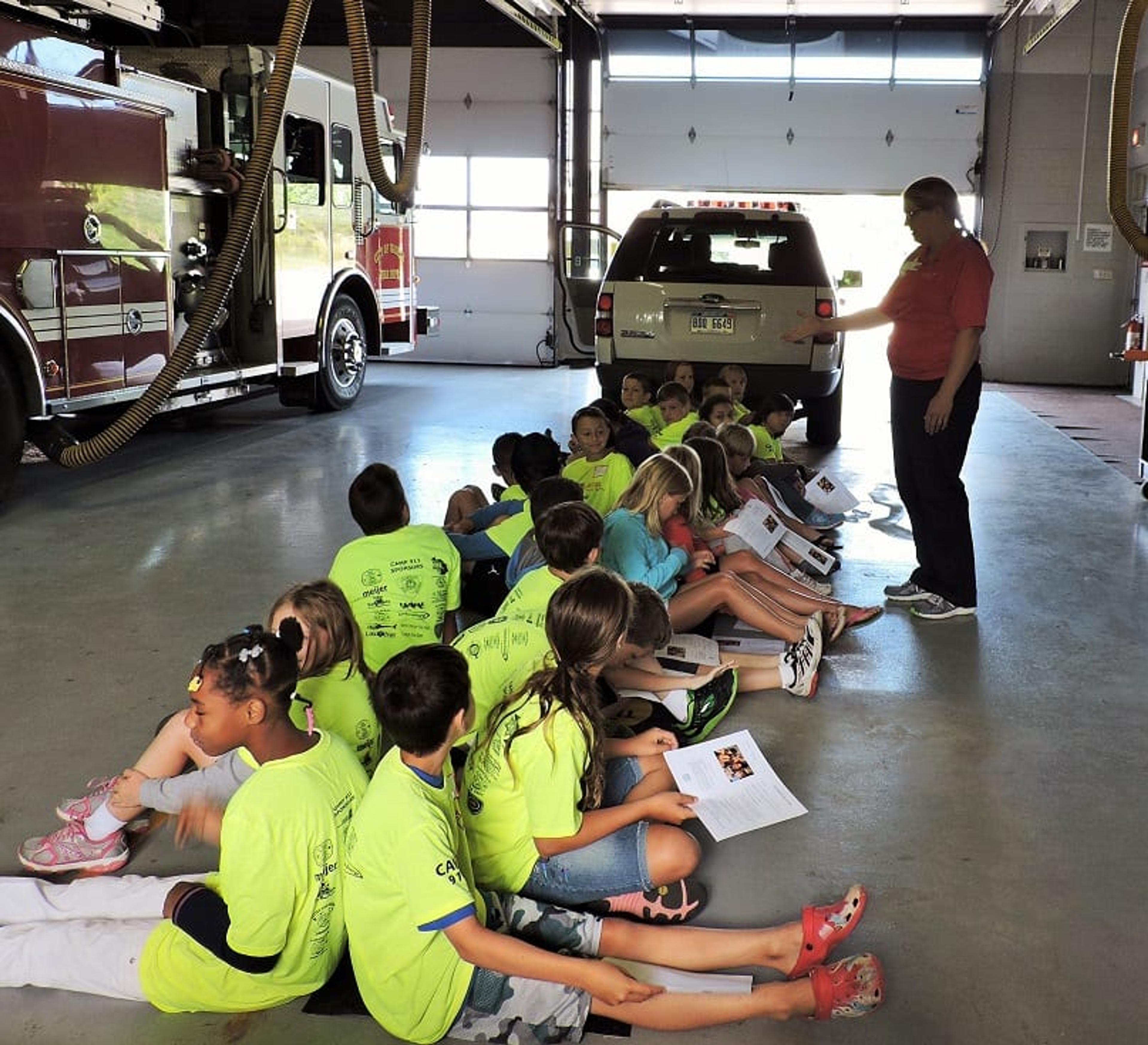 Safe Kids Coordinator Jennifer Hoekstra teaching kids at Camp 911 about the danger of a vehicle's blind spot. Of the kids in this photo, only the last four were visible from the driver's seat. 