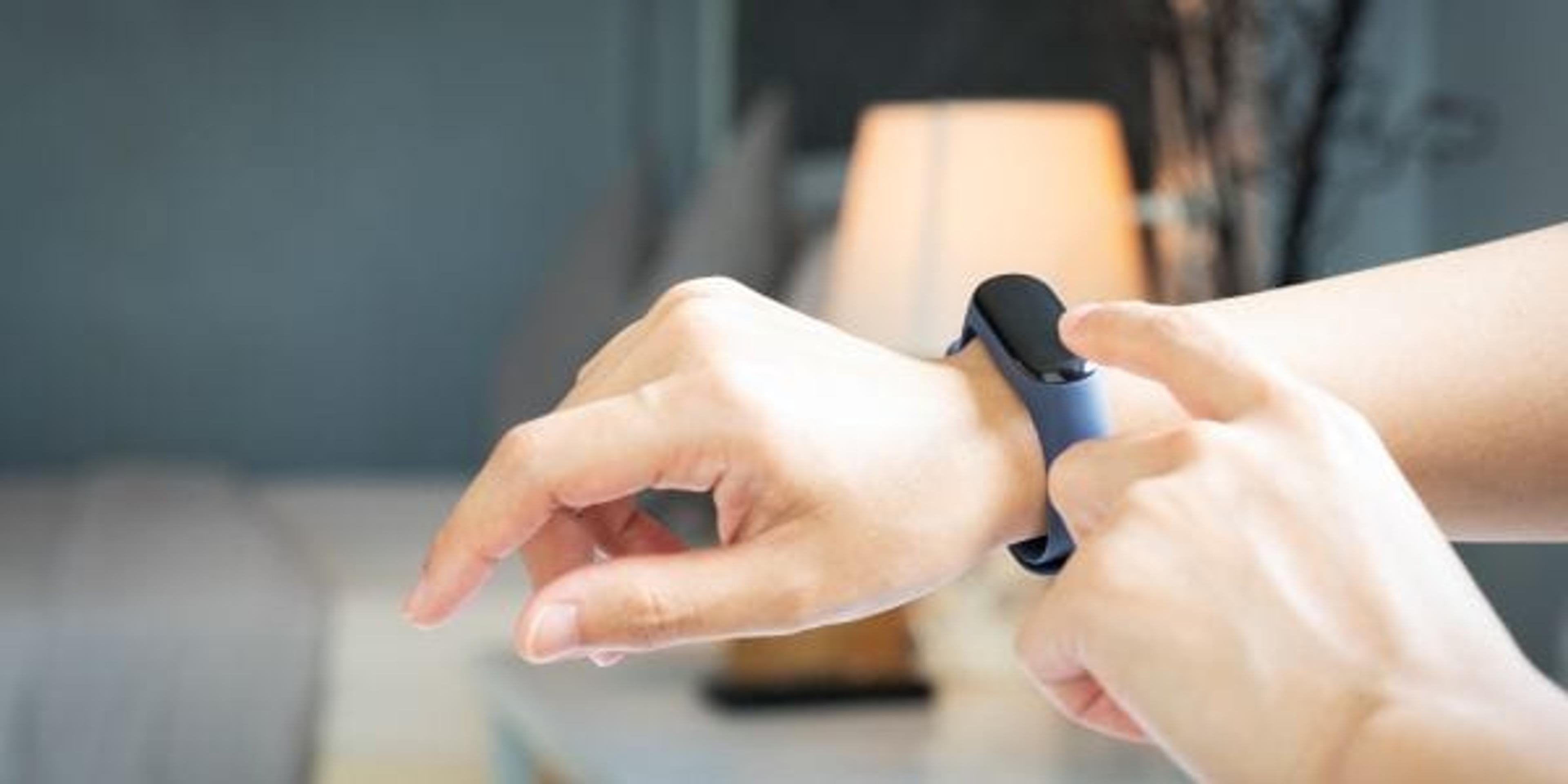 Woman checking her sleep tracker before bed.