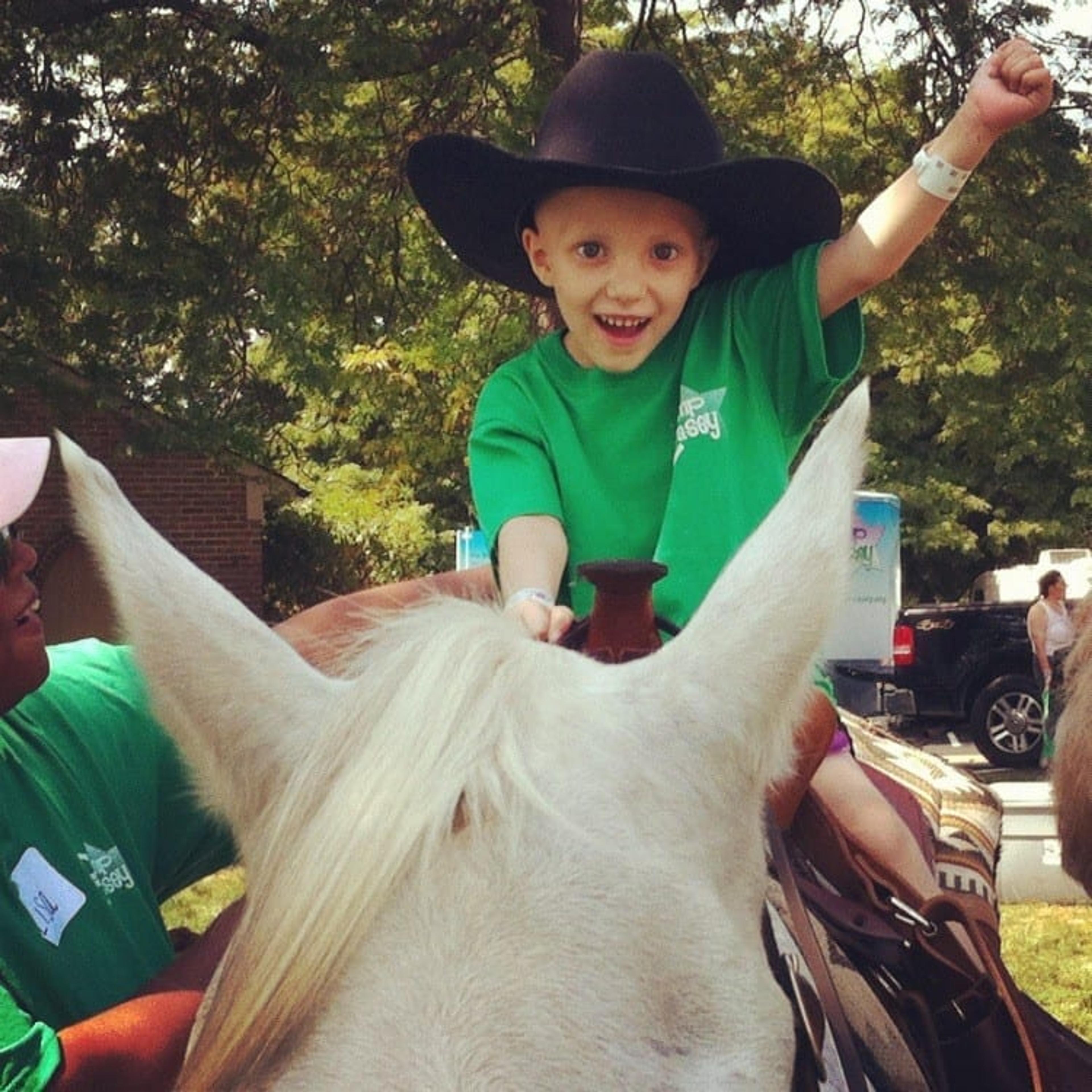 little boy smiling on horseback