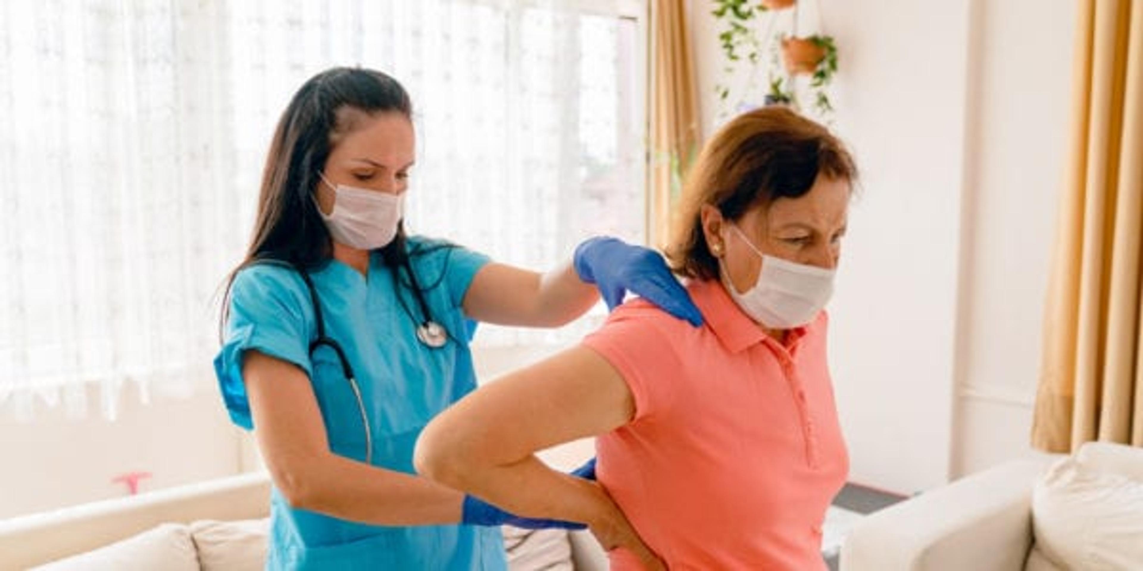 Home health care worker helps woman stretch