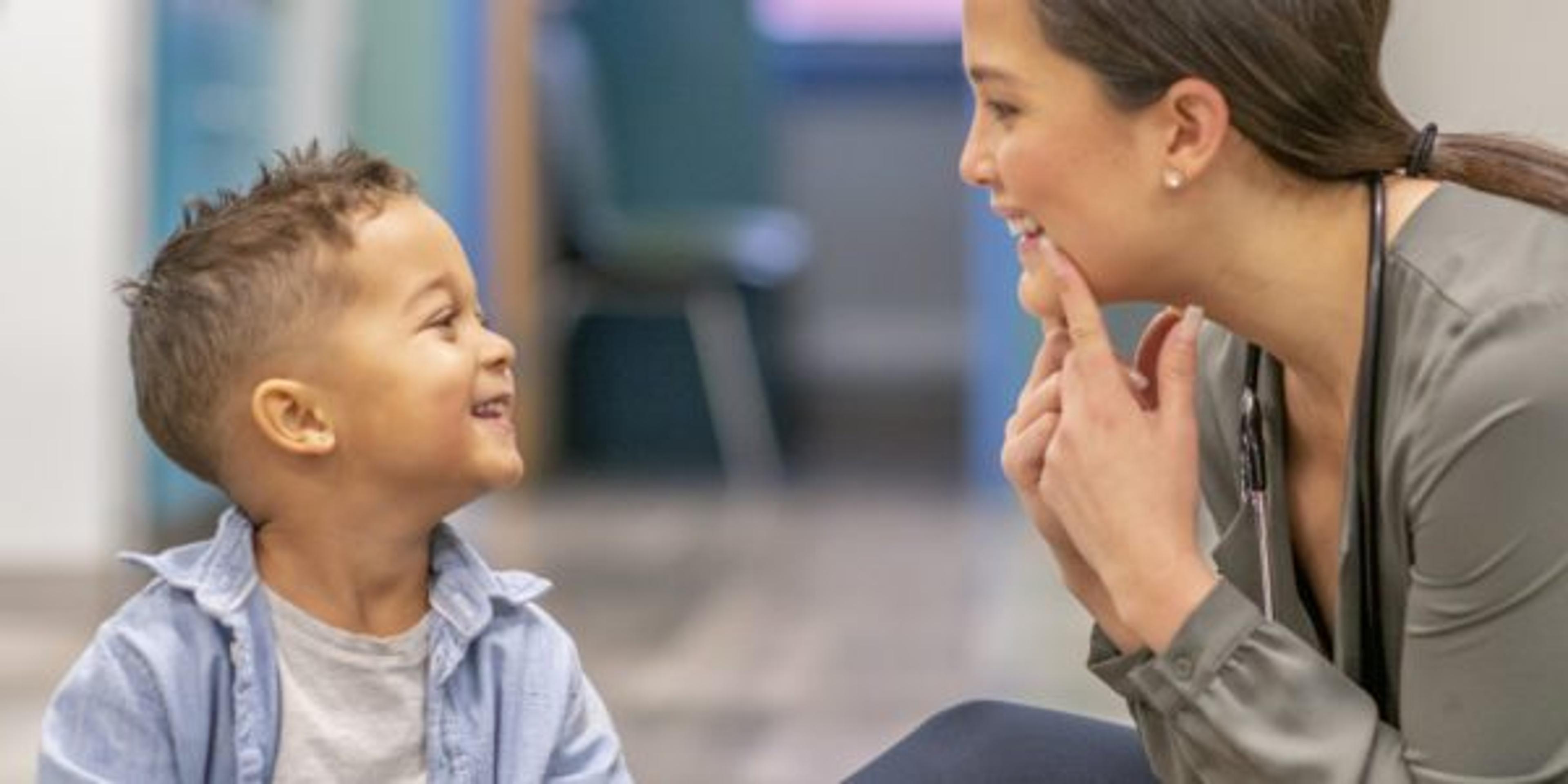 A speech therapist teaches a young boy how to sound out words.