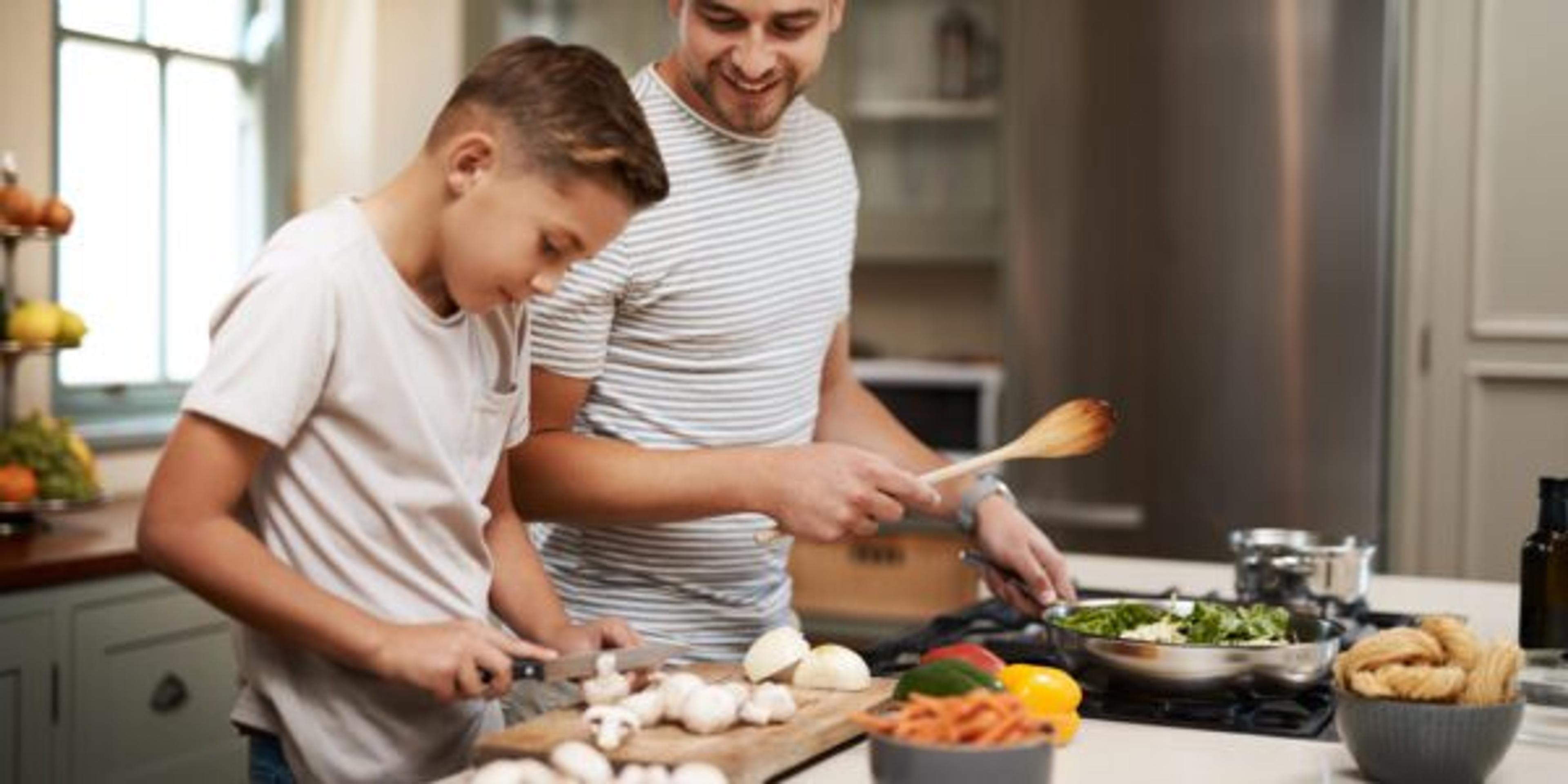 Cropped shot of a young boy helping his father cook in the kitchen