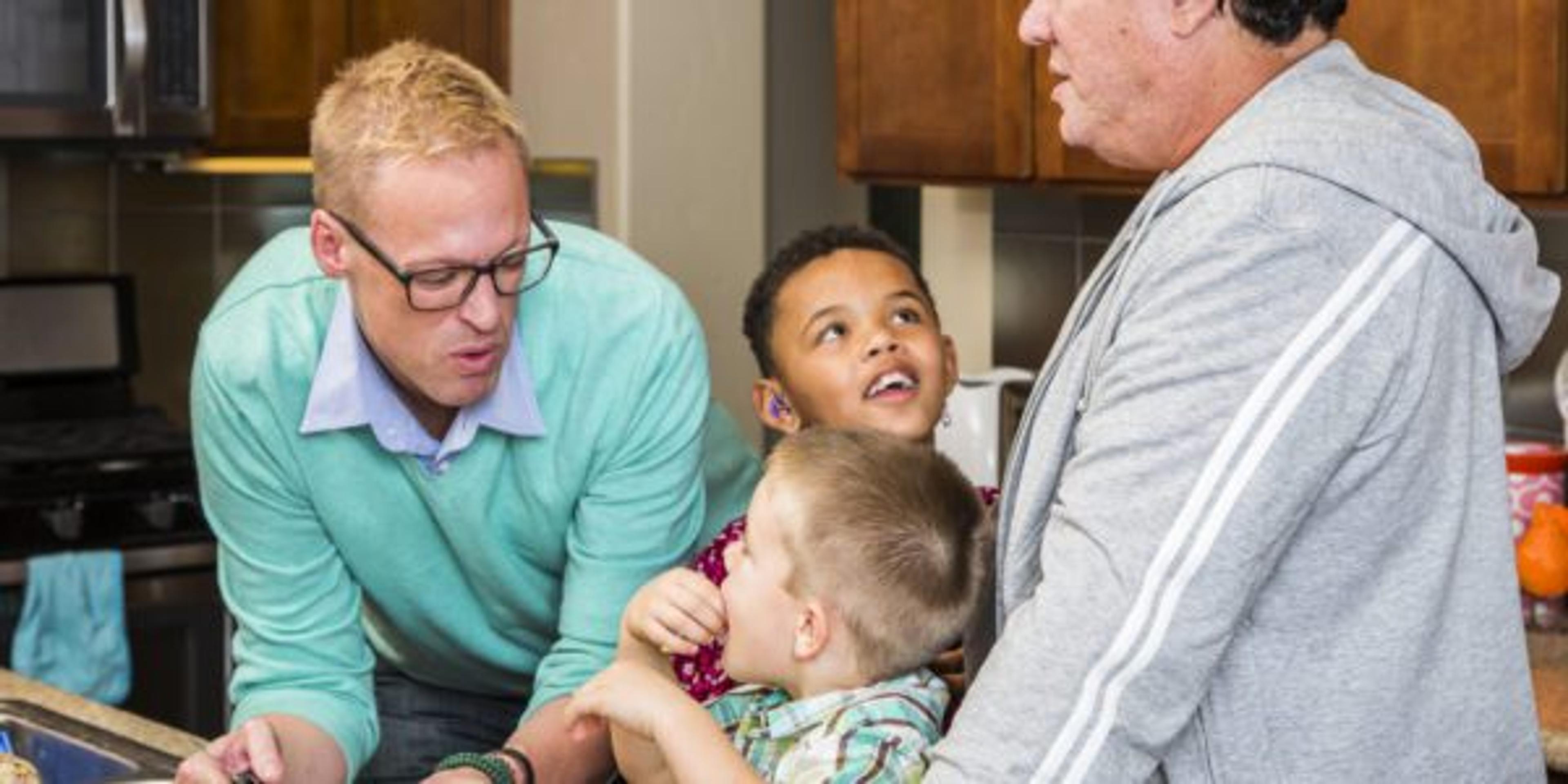 Preparing a meal with gay couple and kids in their home kitchen