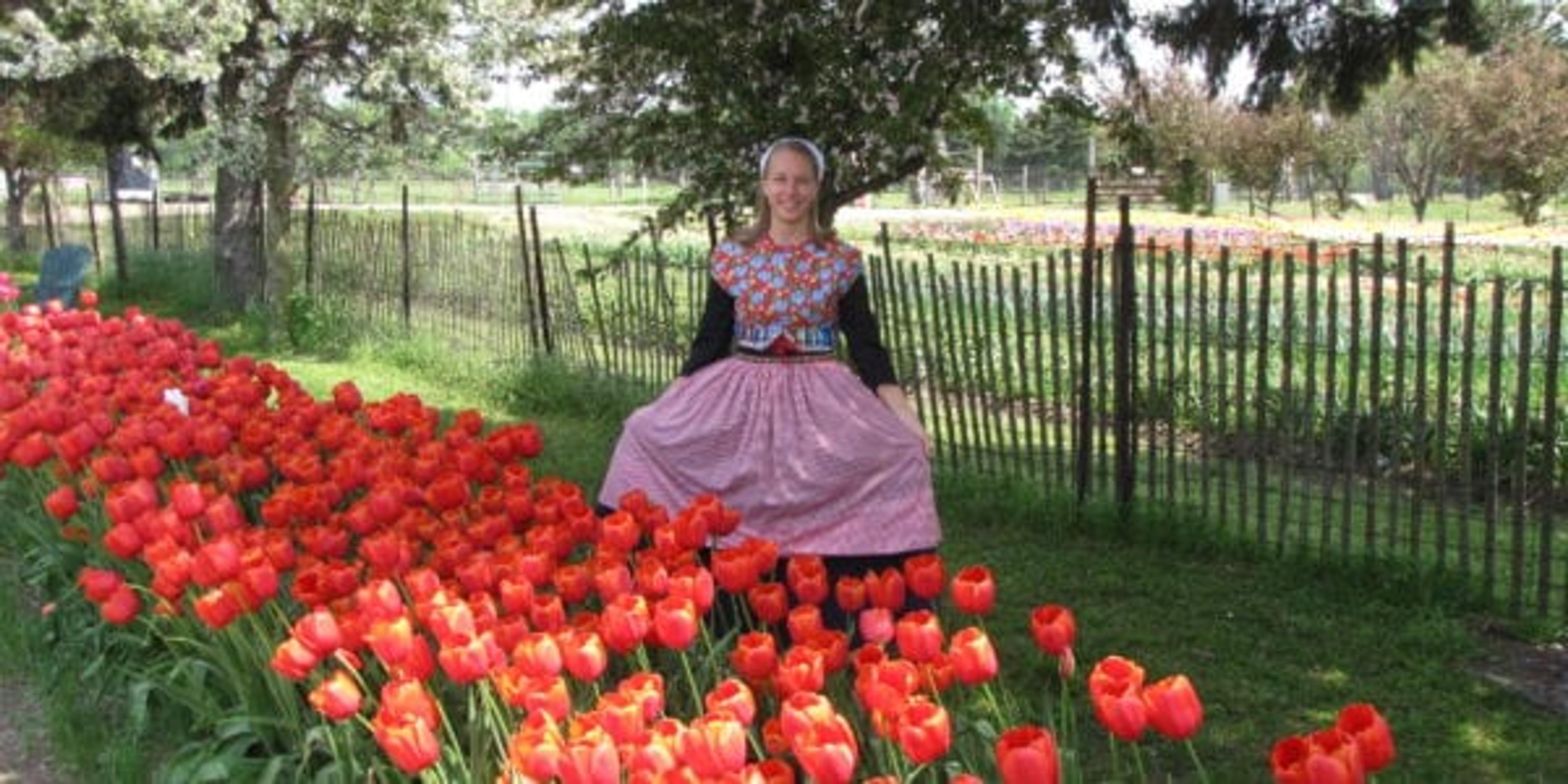 Nicole Prins in front of Tulips in a Dutch outfit