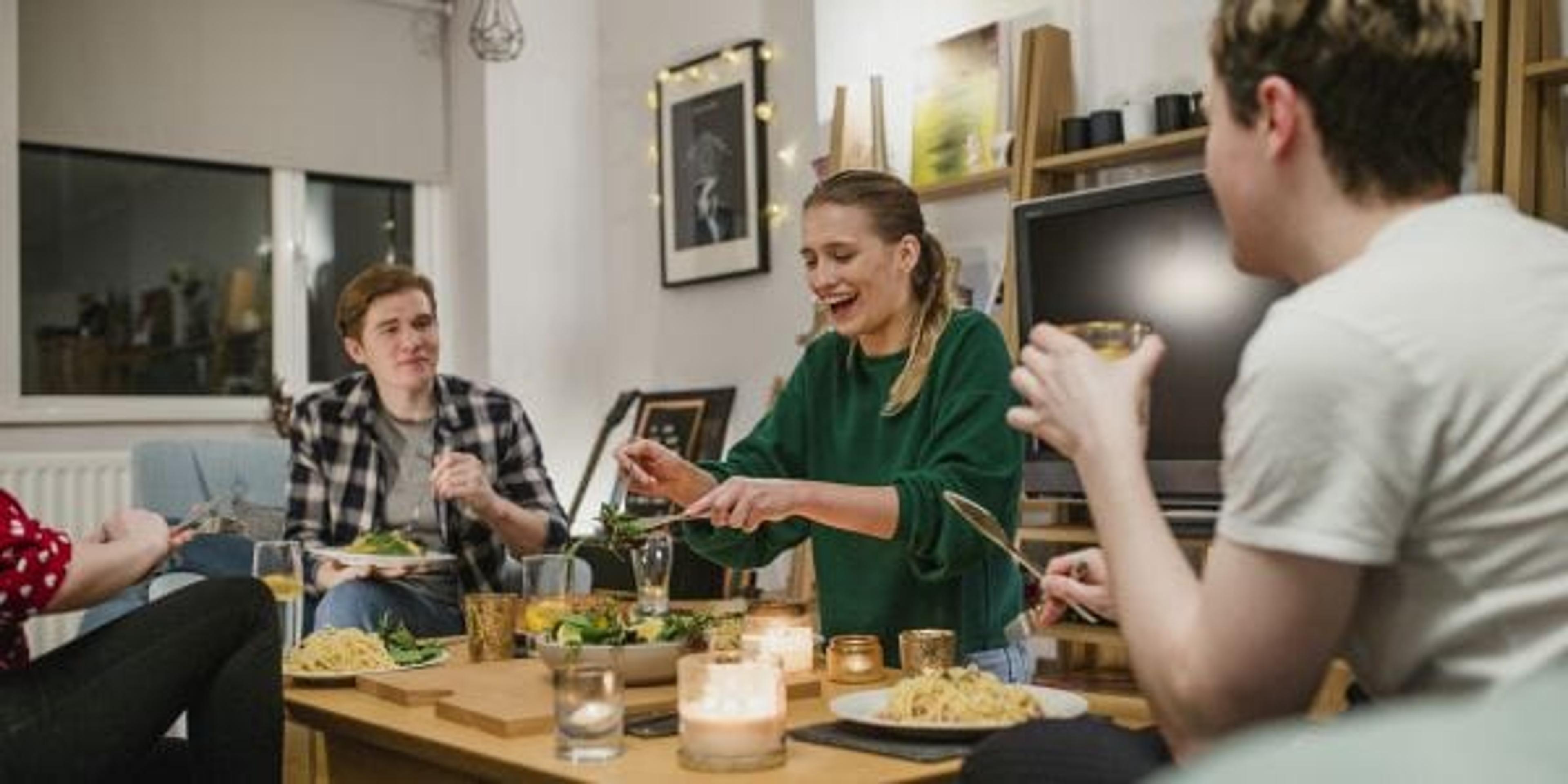 Young college students having dinner together