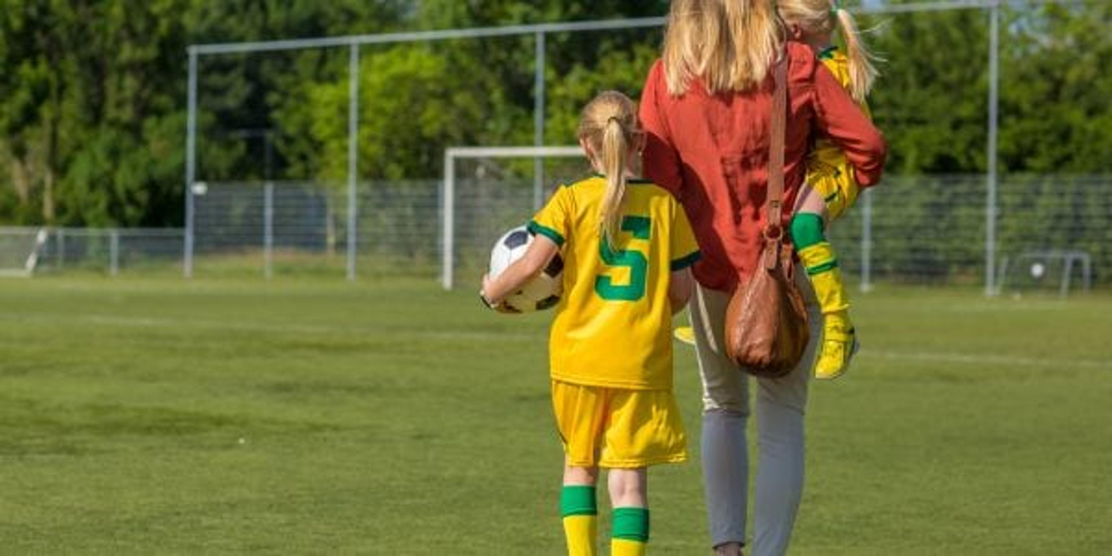 Soccer Mom accompanying her two daughters to football training