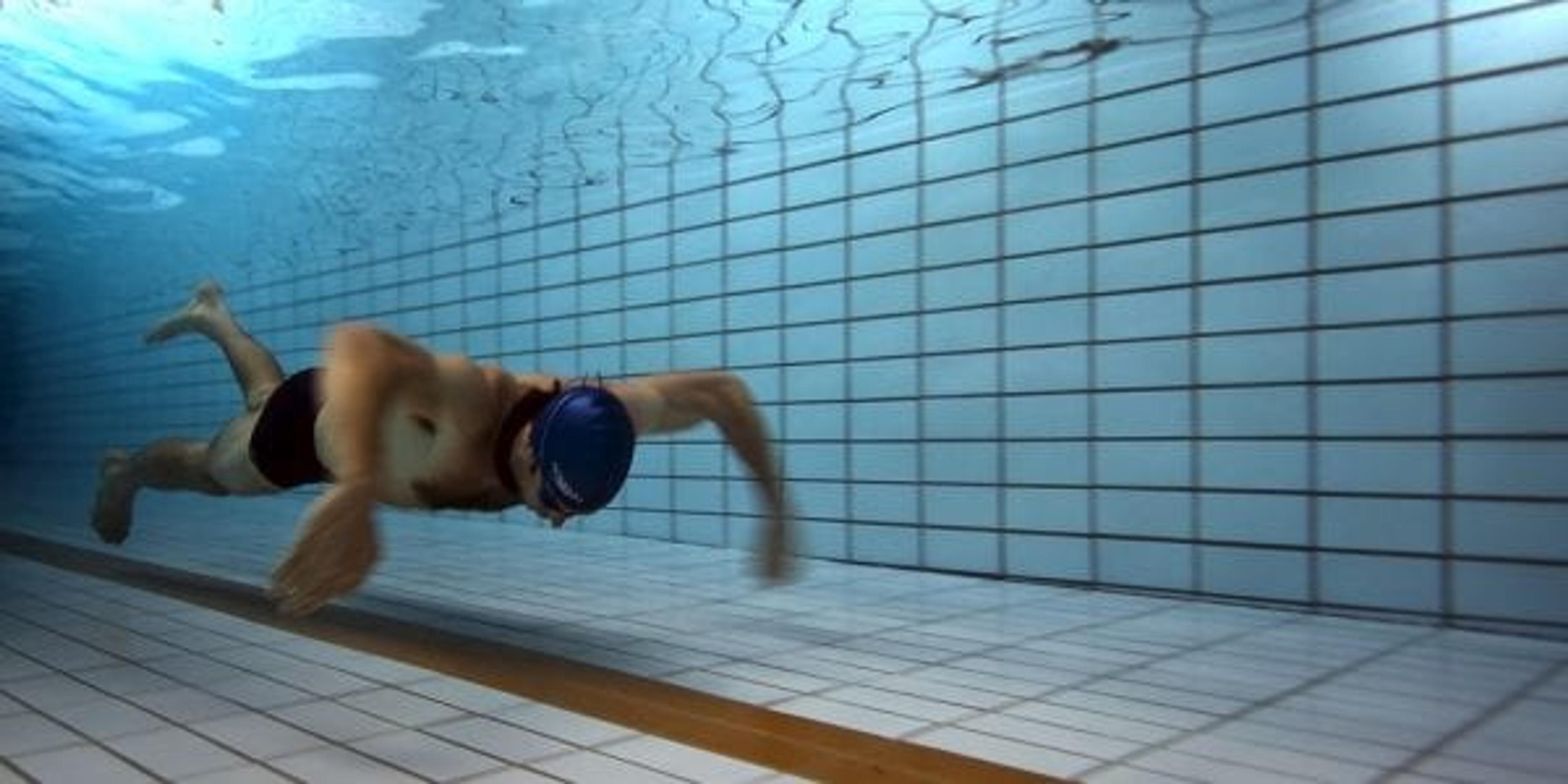 A swimmer underwater in a pool