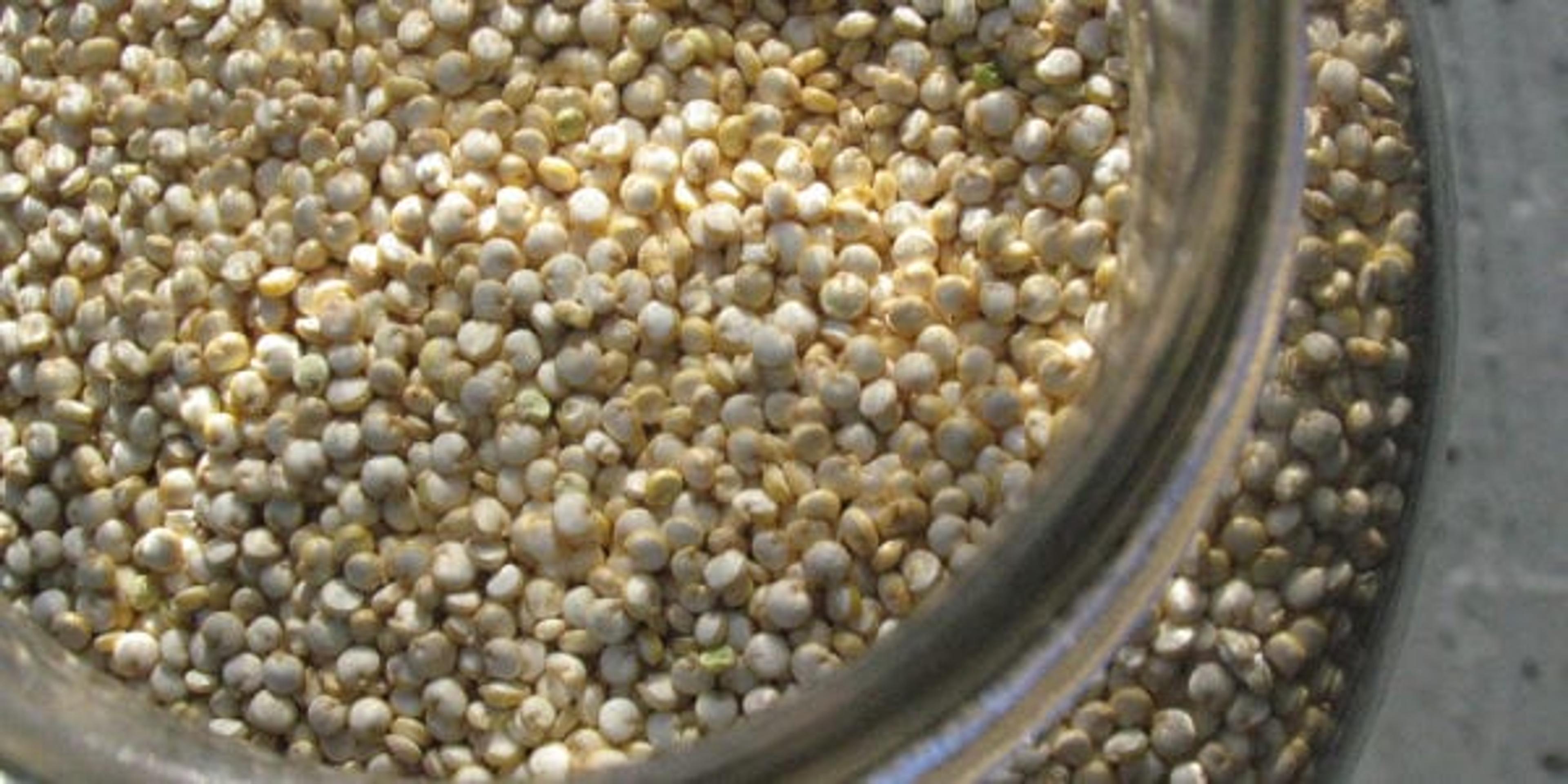 Close-up photo of a clear glass jar of quinoa, shot from the top.
