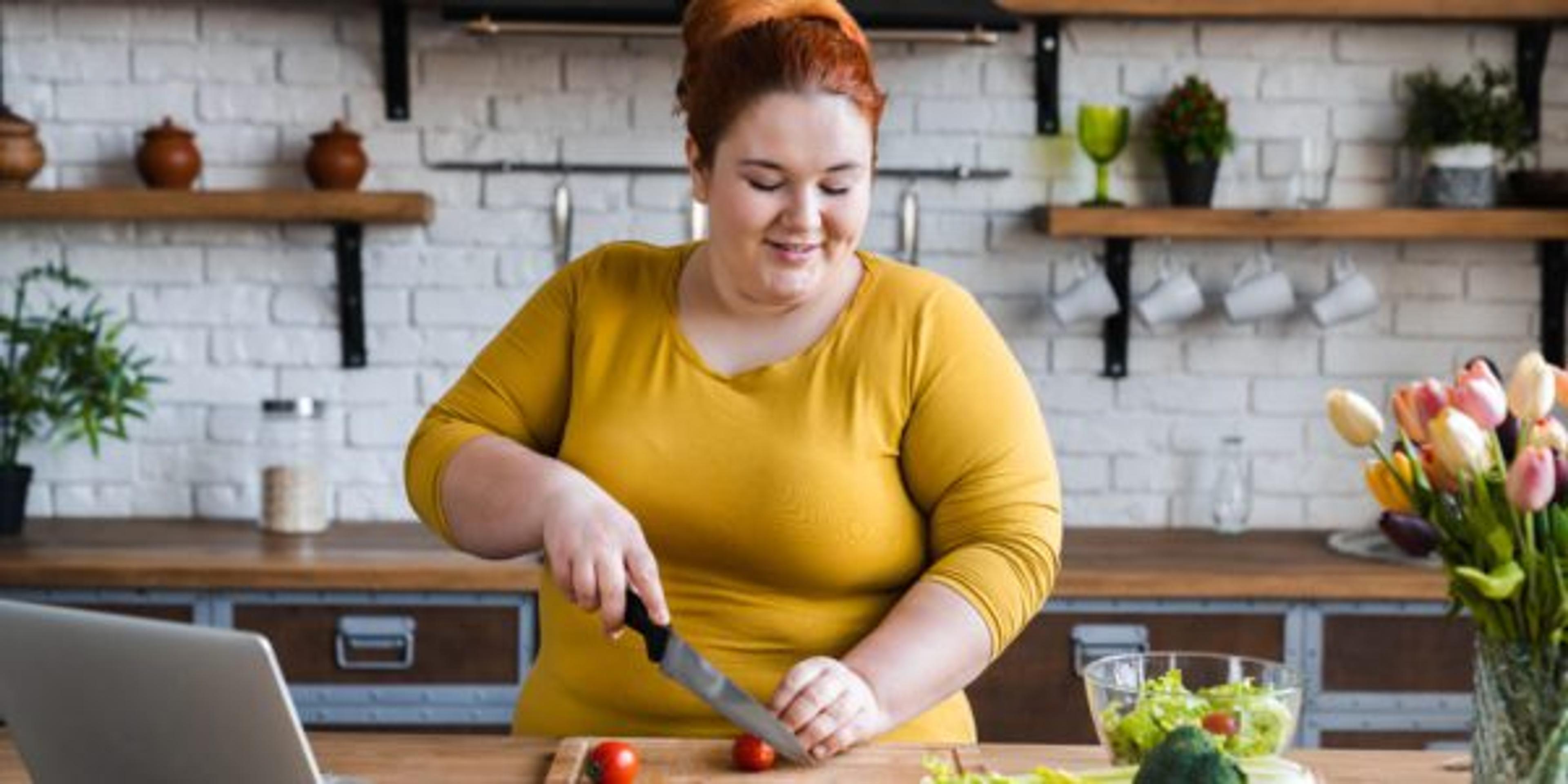 Plus size , caucasian woman learning to make salad and healthy food from social media,Social distancing, stay at home concept