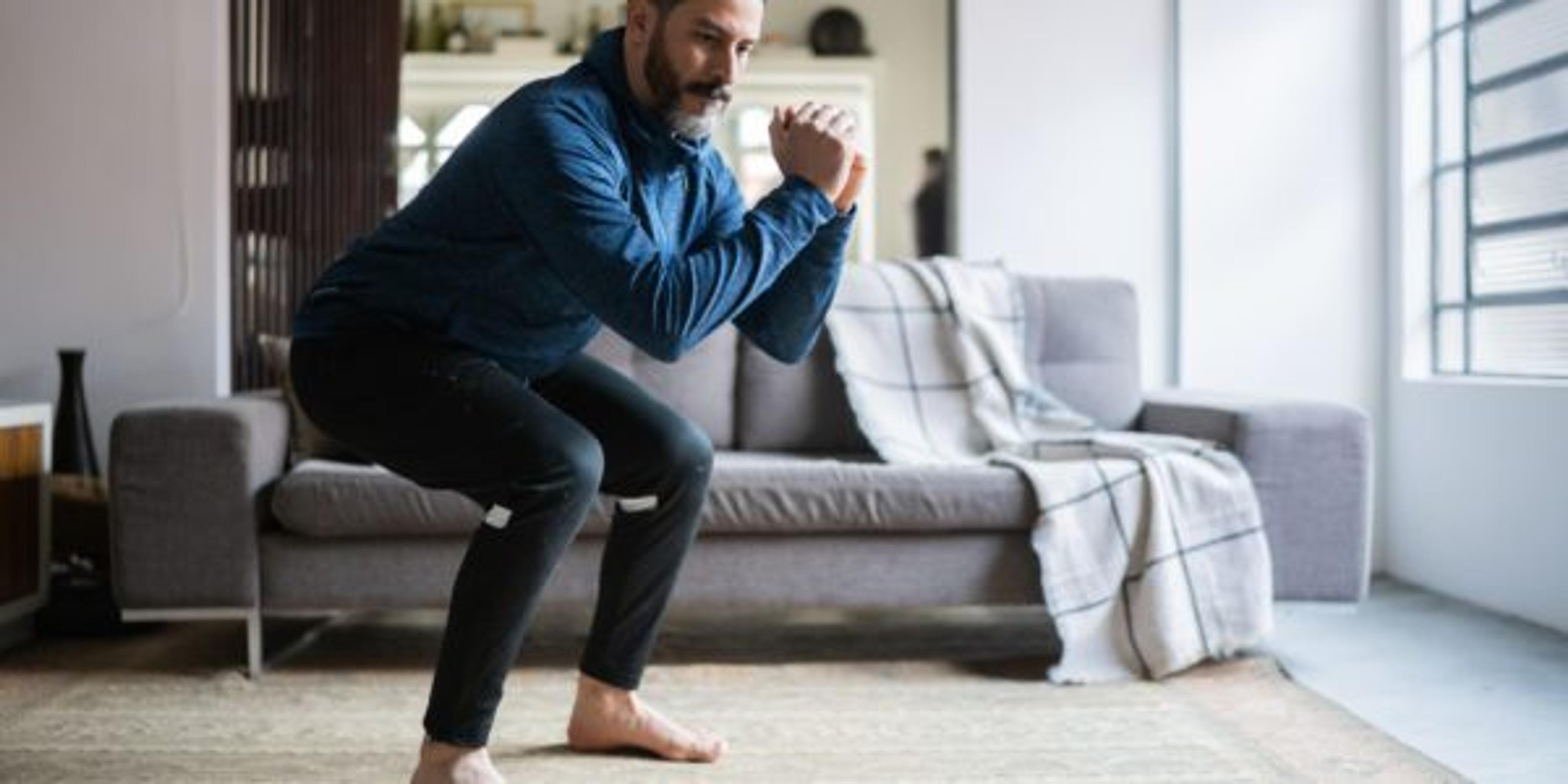 Mature man squatting at home