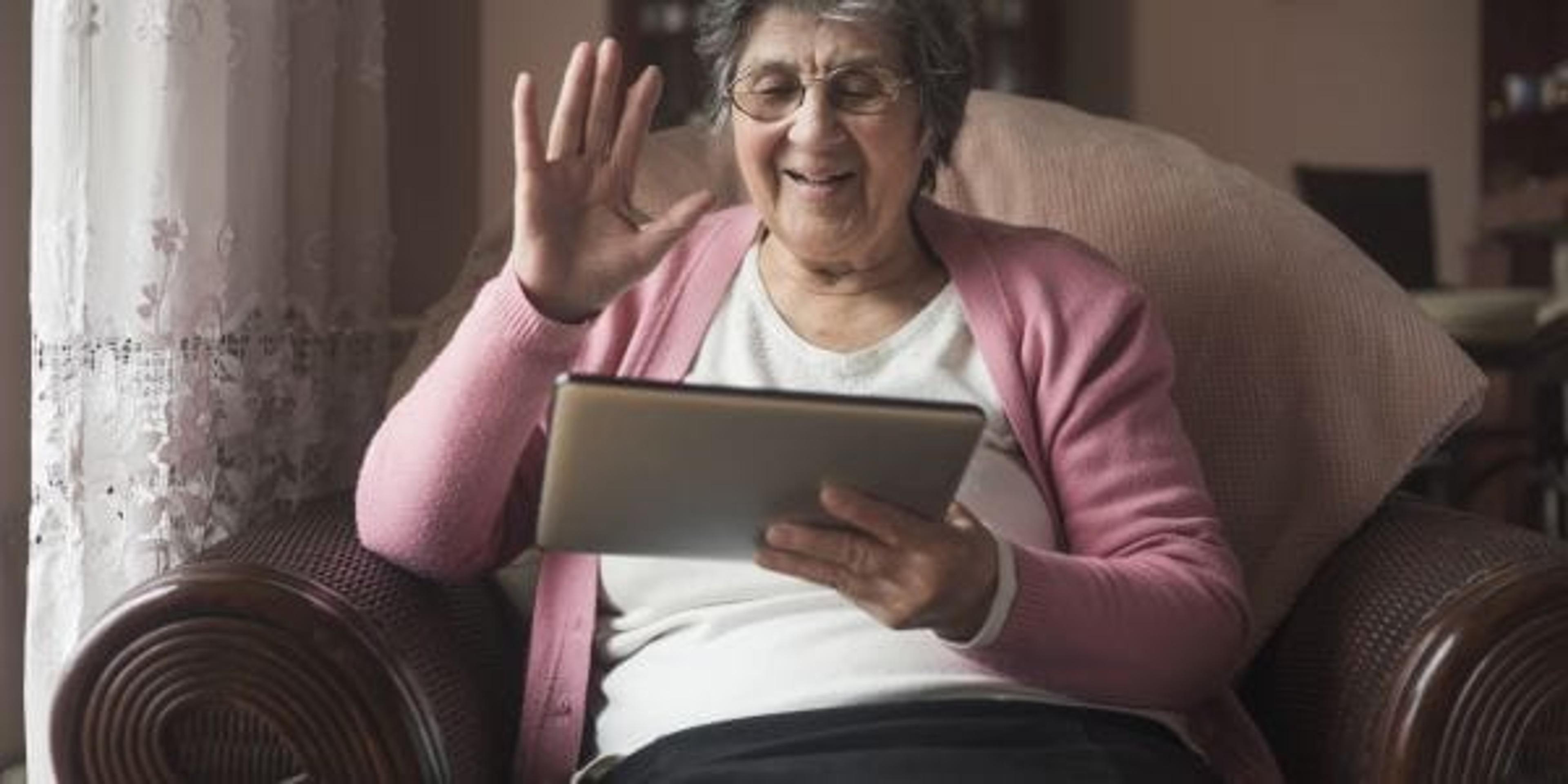 Elderly woman using Skype to talk to her family.