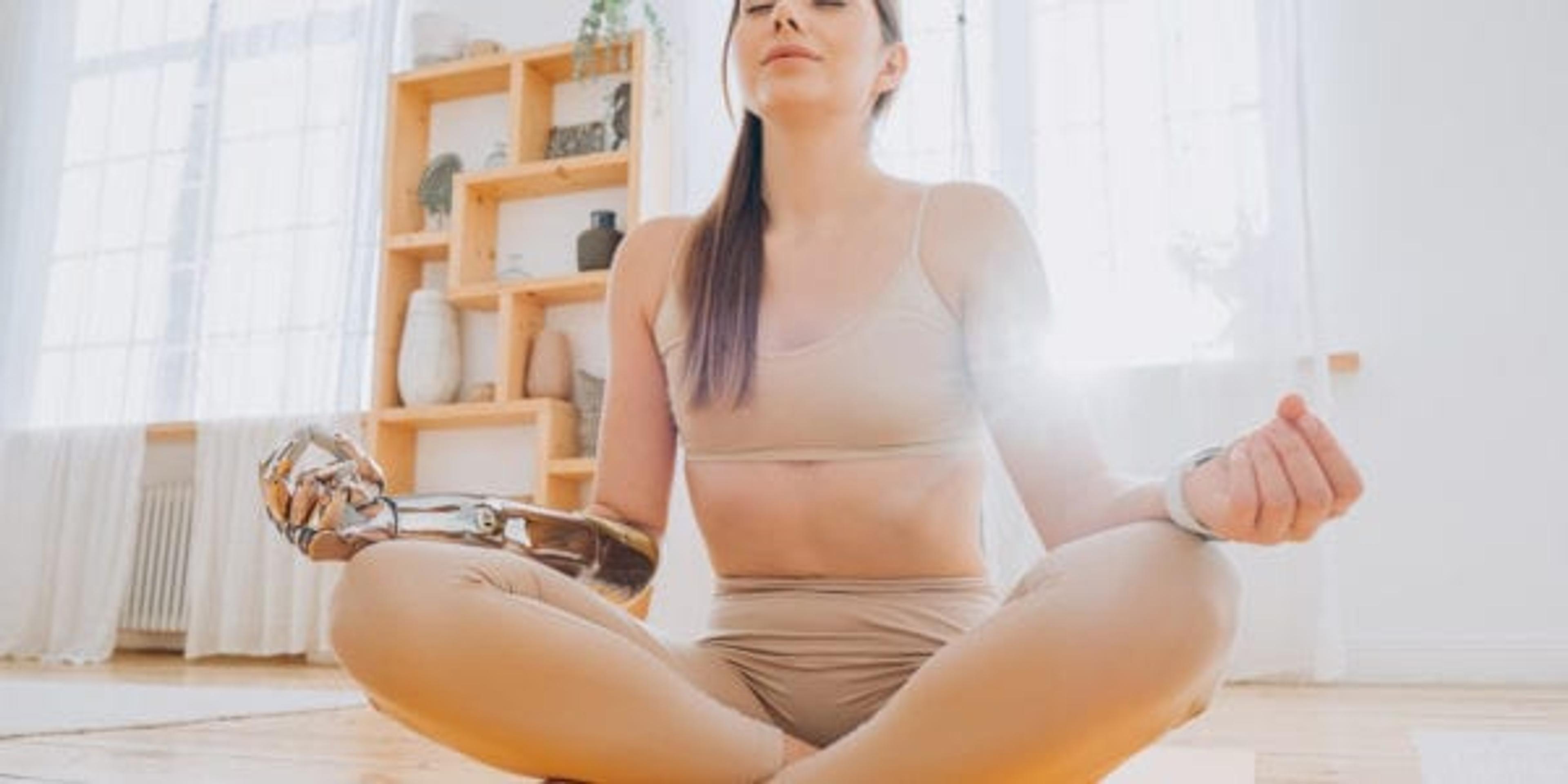 Peaceful young woman with modern metal prosthesis bionic arm in tracksuit meditates sitting by window in sunny room closeup