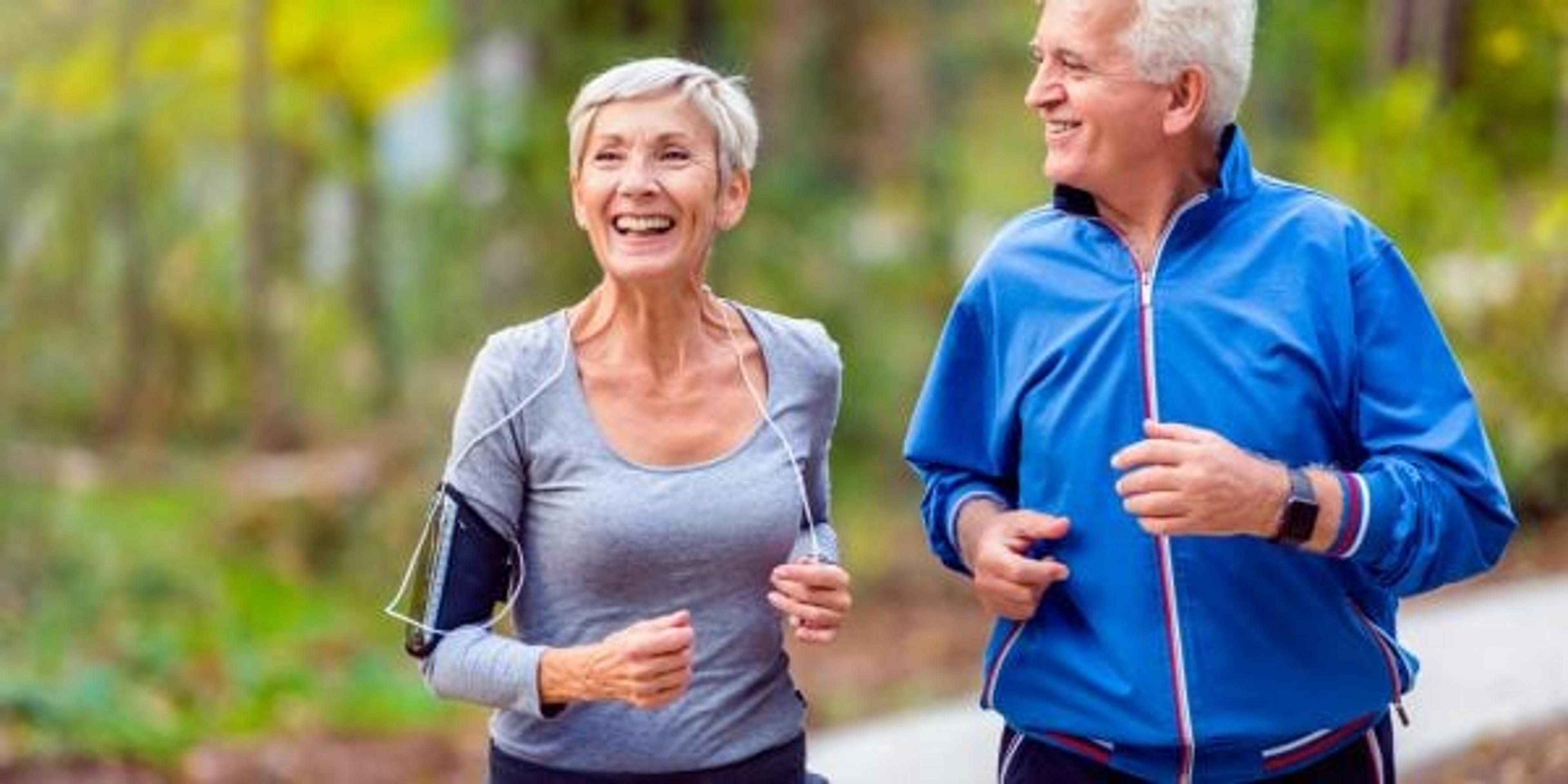 Smiling senior couple jogging in the park