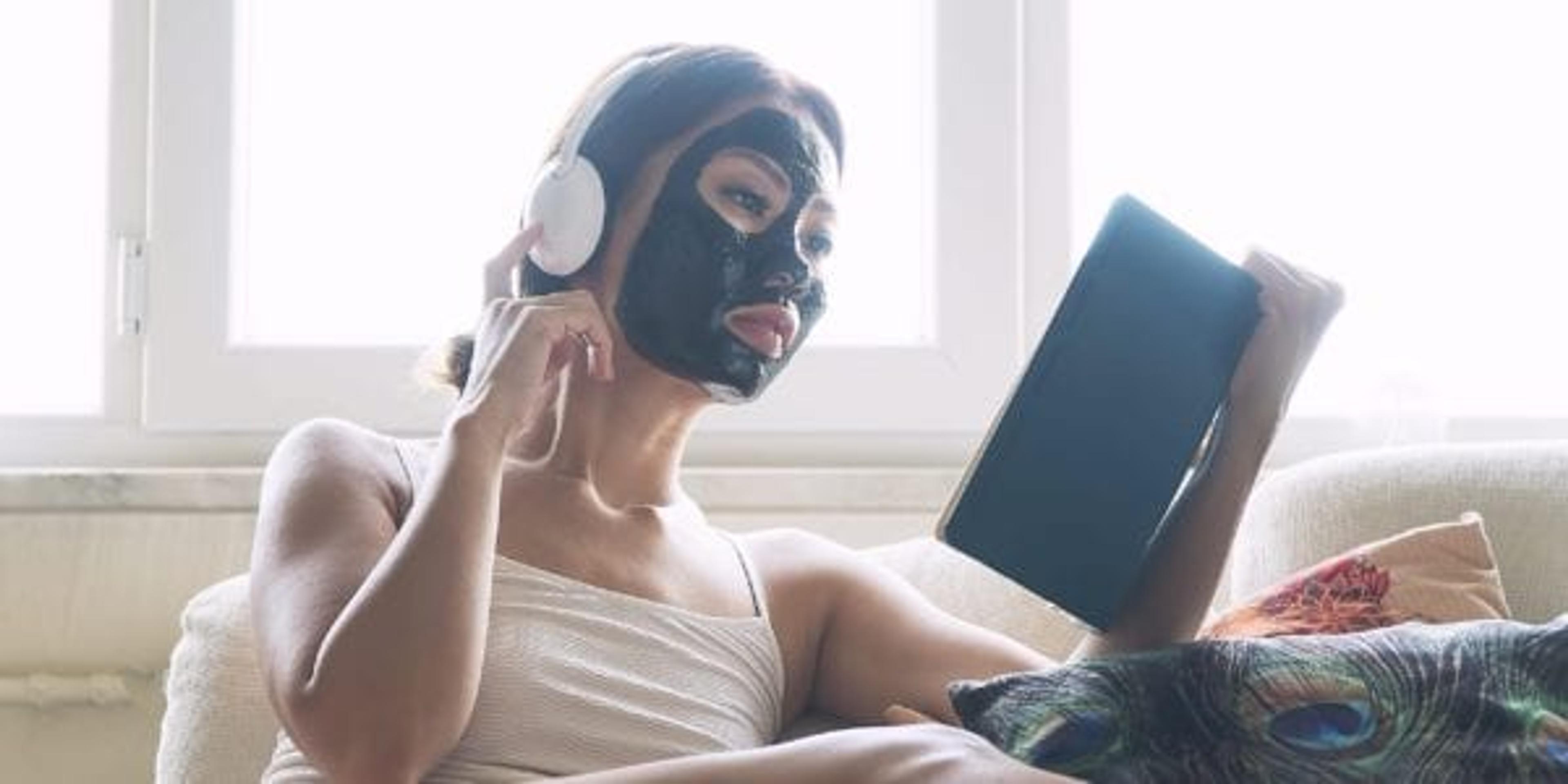 Woman chilling out with charcoal face mask on face