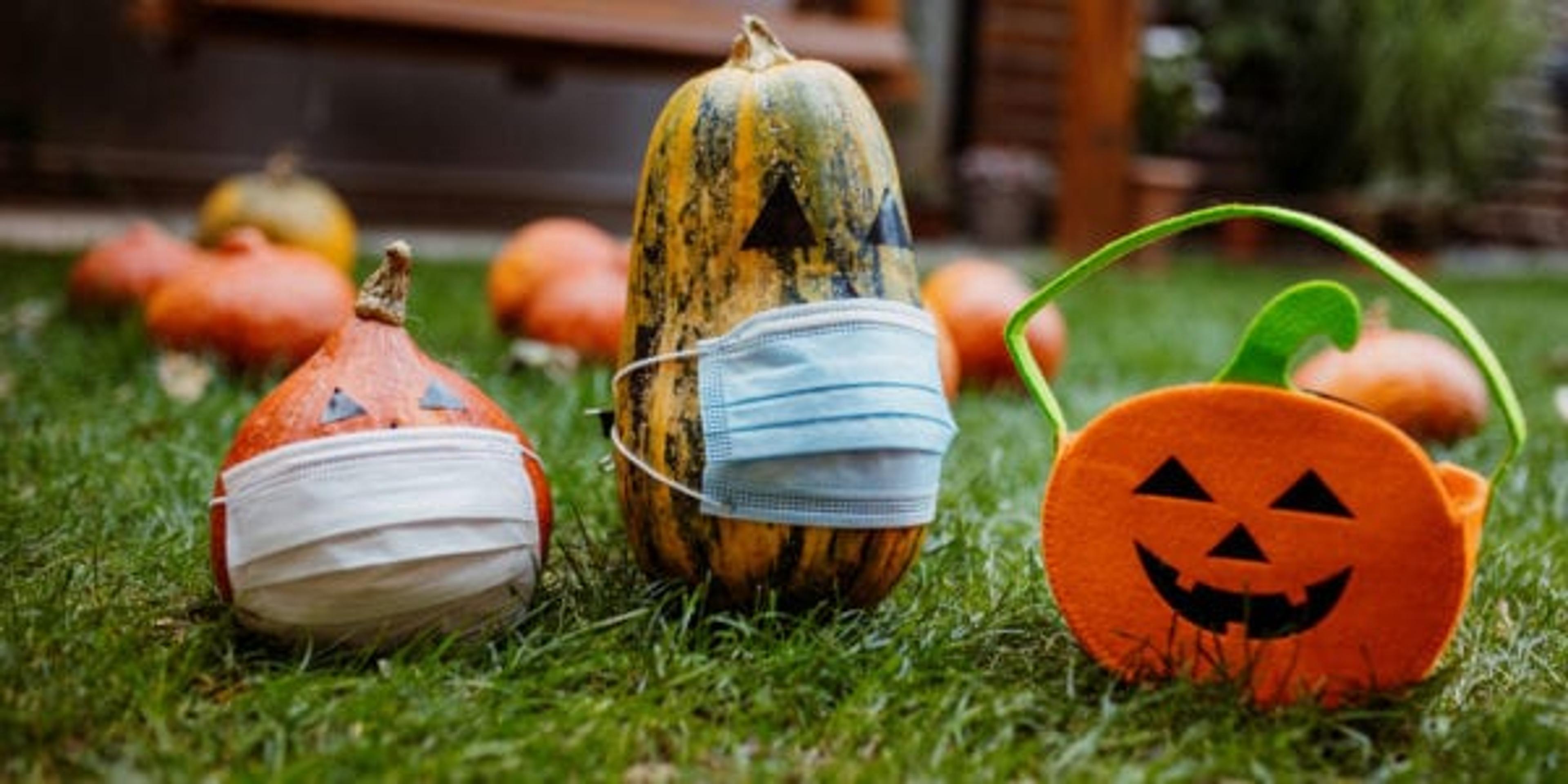 Pumpkins on the grass with face protective mask during Covid-19 pandemic