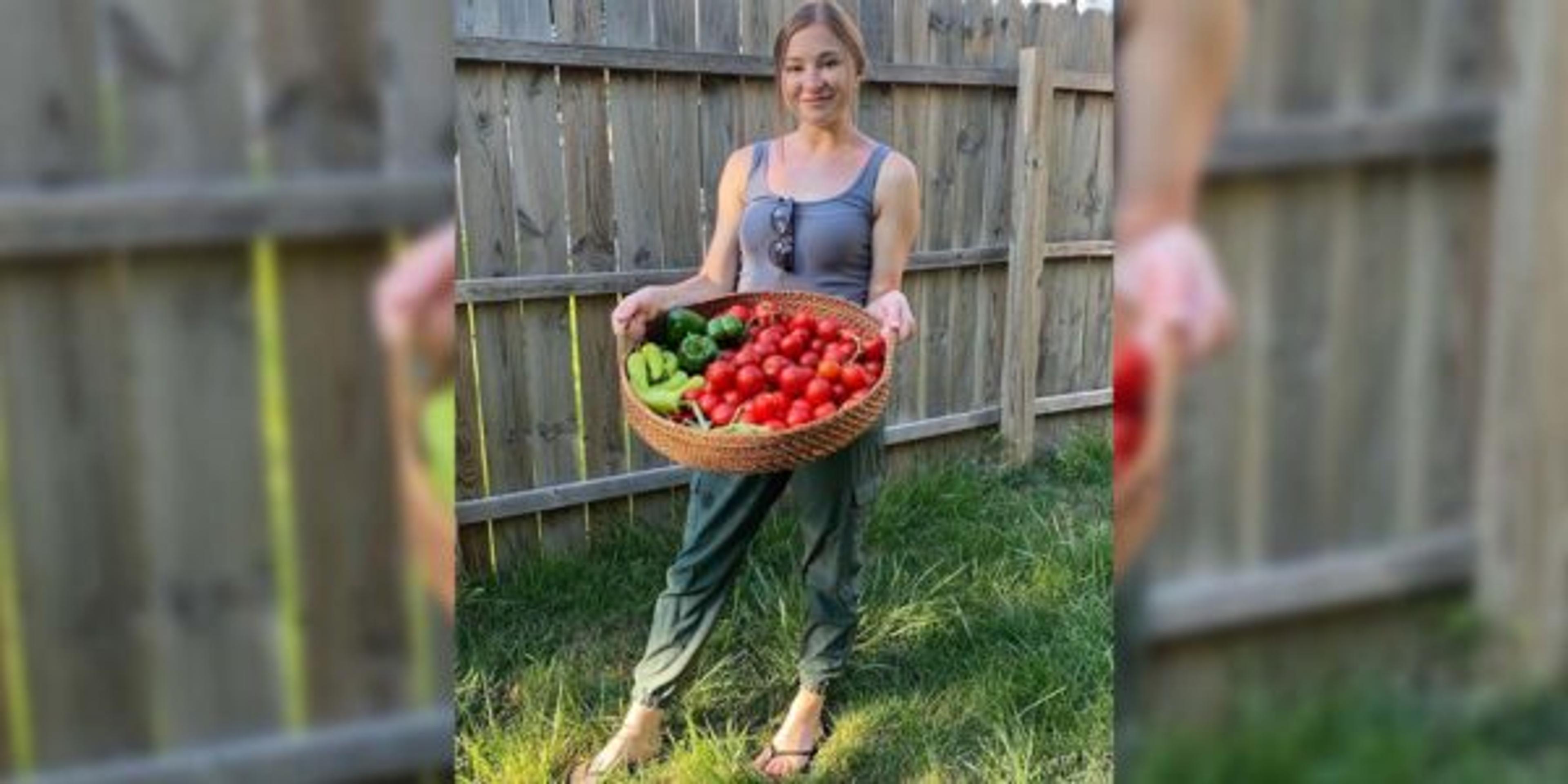 Mia poses with a basket full of tomatoes from her garden