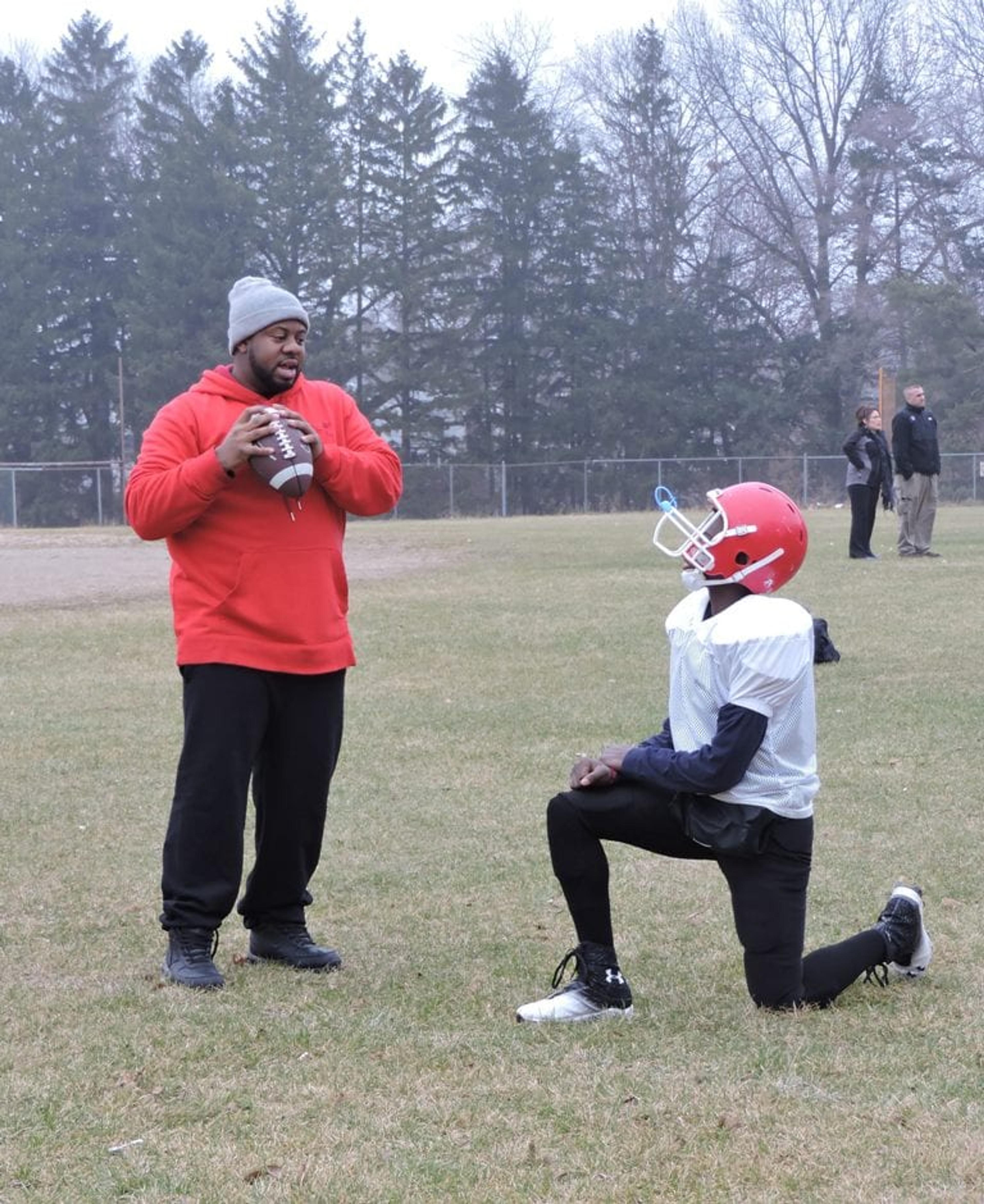 Head coach Uriel Tyler works with a player on form. 