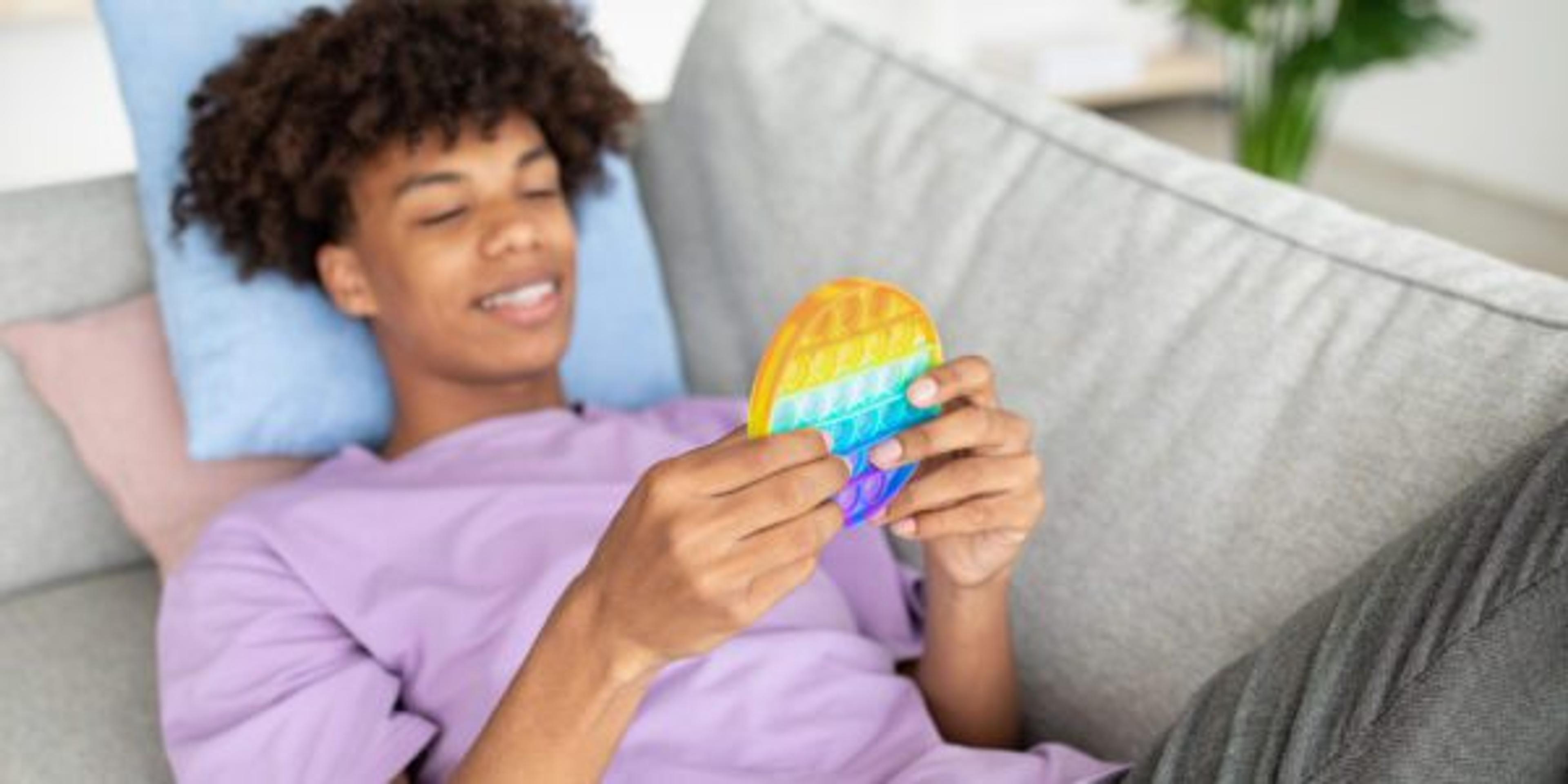 Teenage boy playing with a popper on the couch