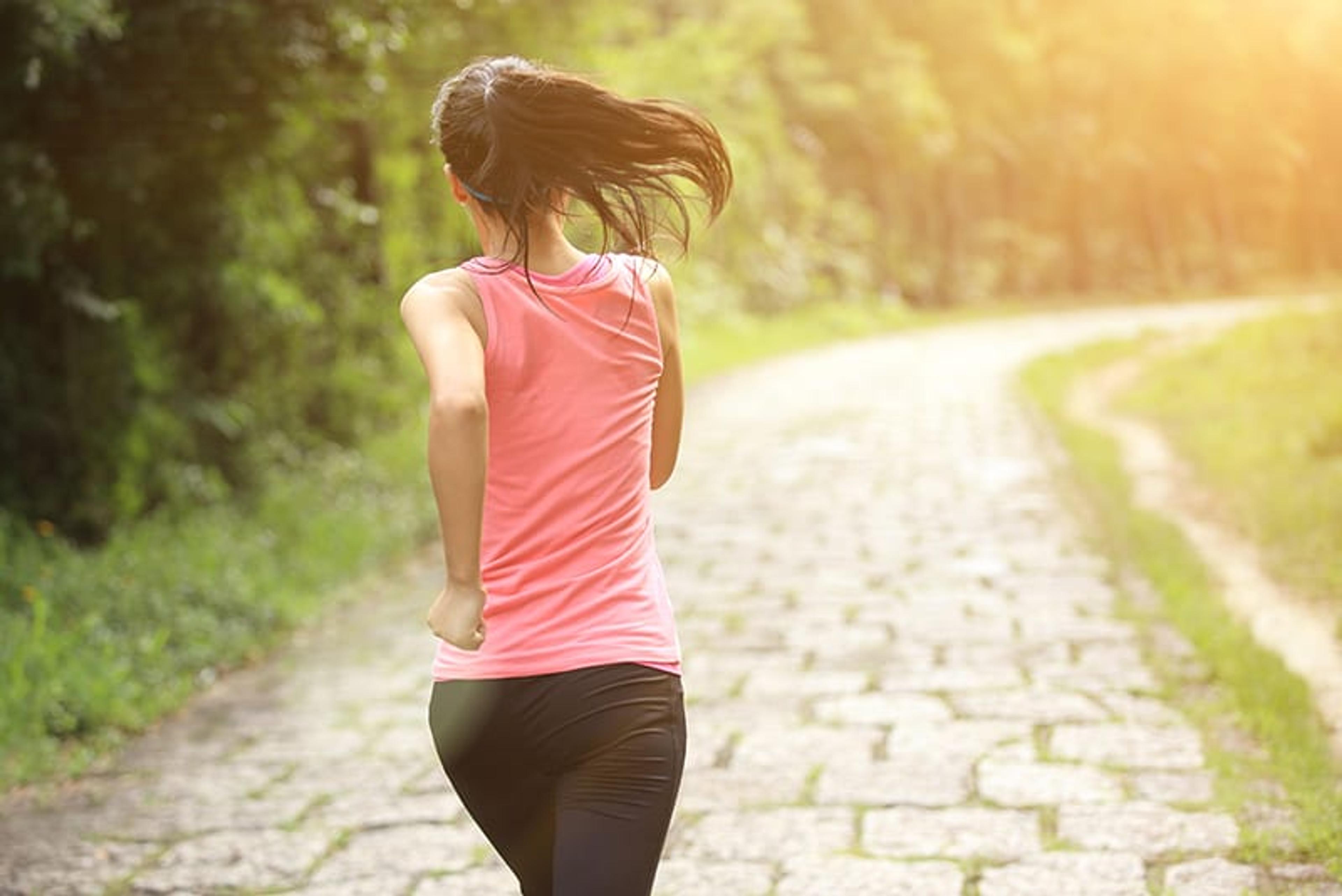 woman runner athlete running on forest trail