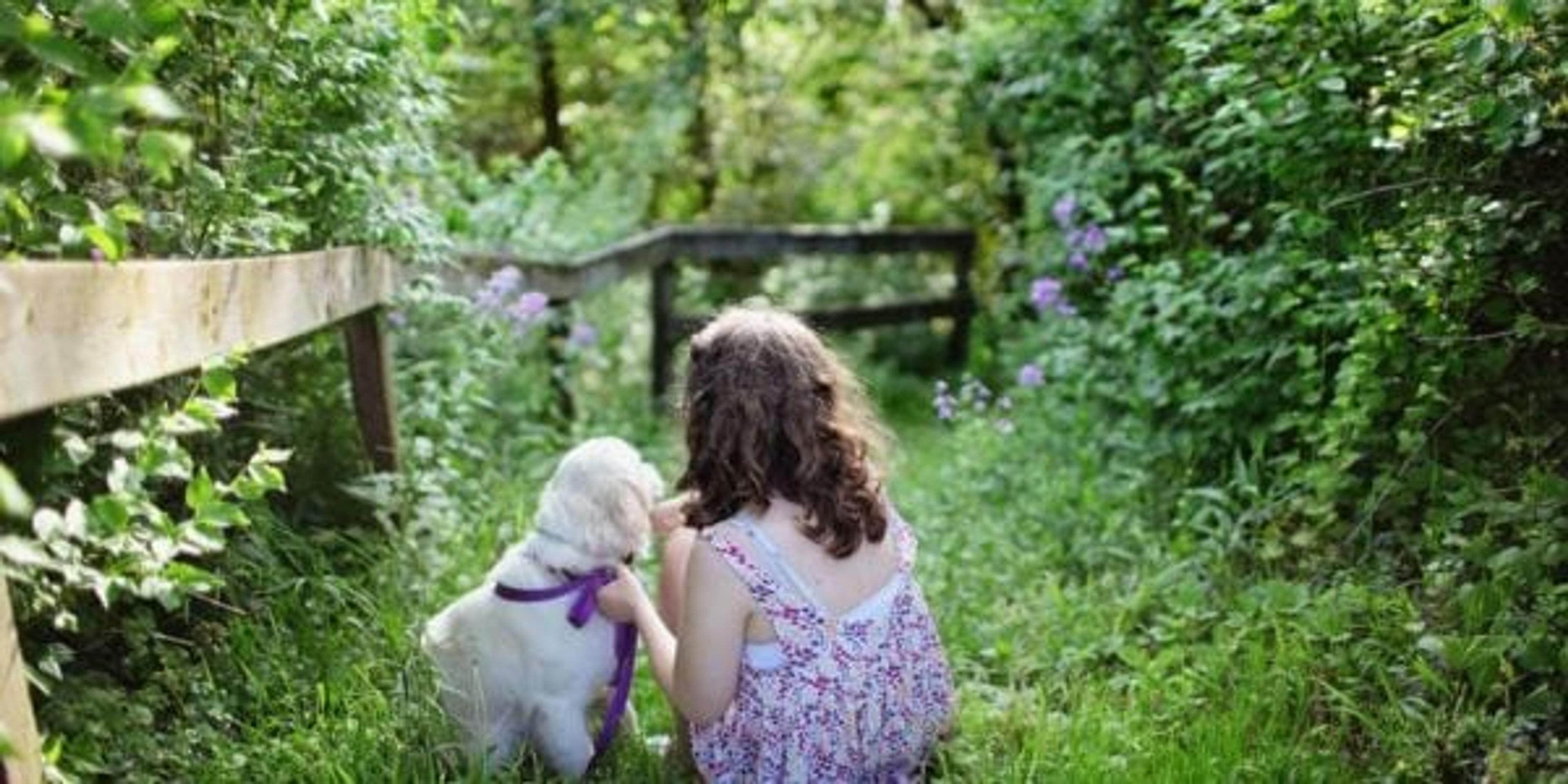 Girl outside in woods with puppy