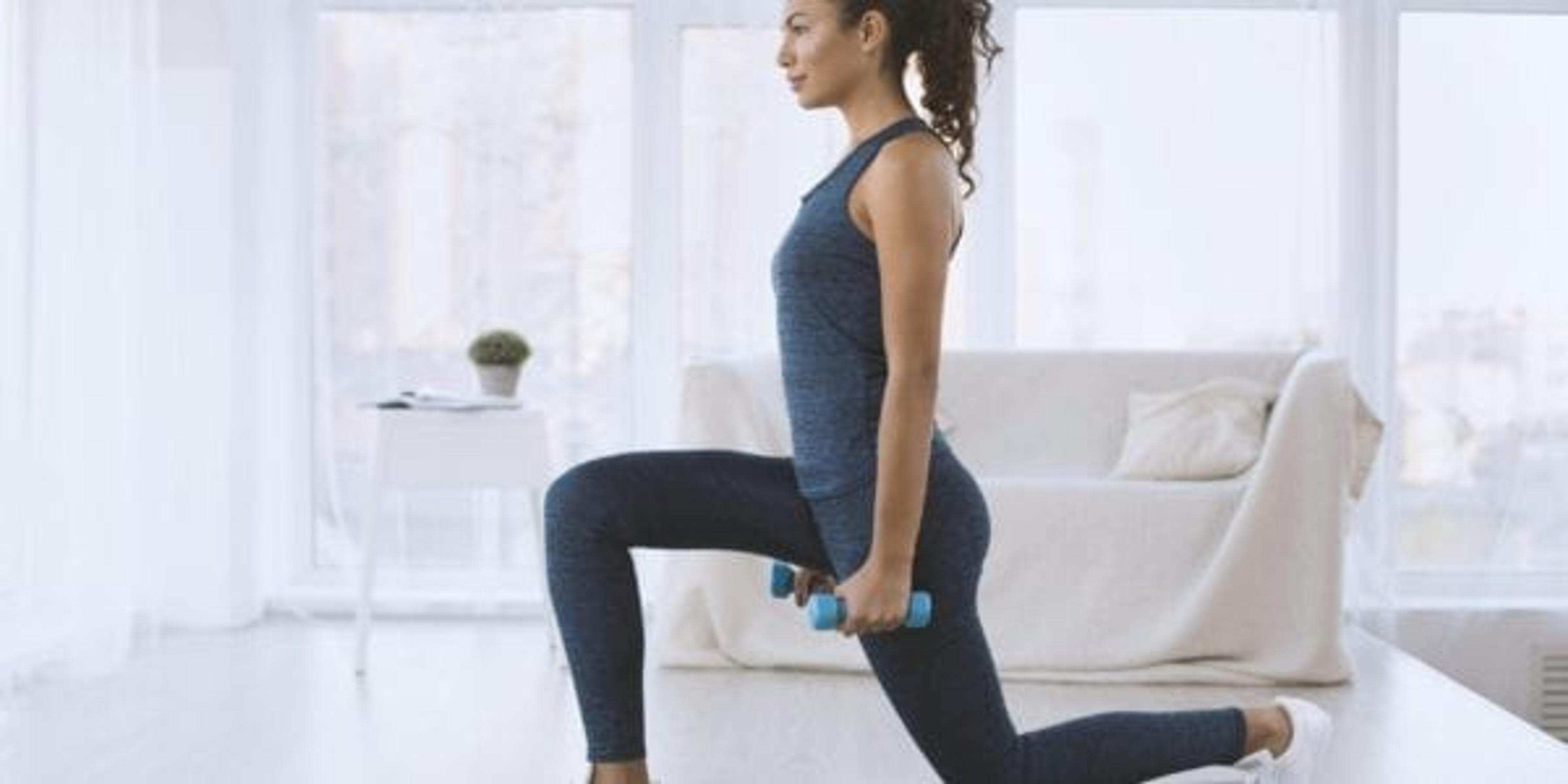 Girl doing lunges with dumbbells at home