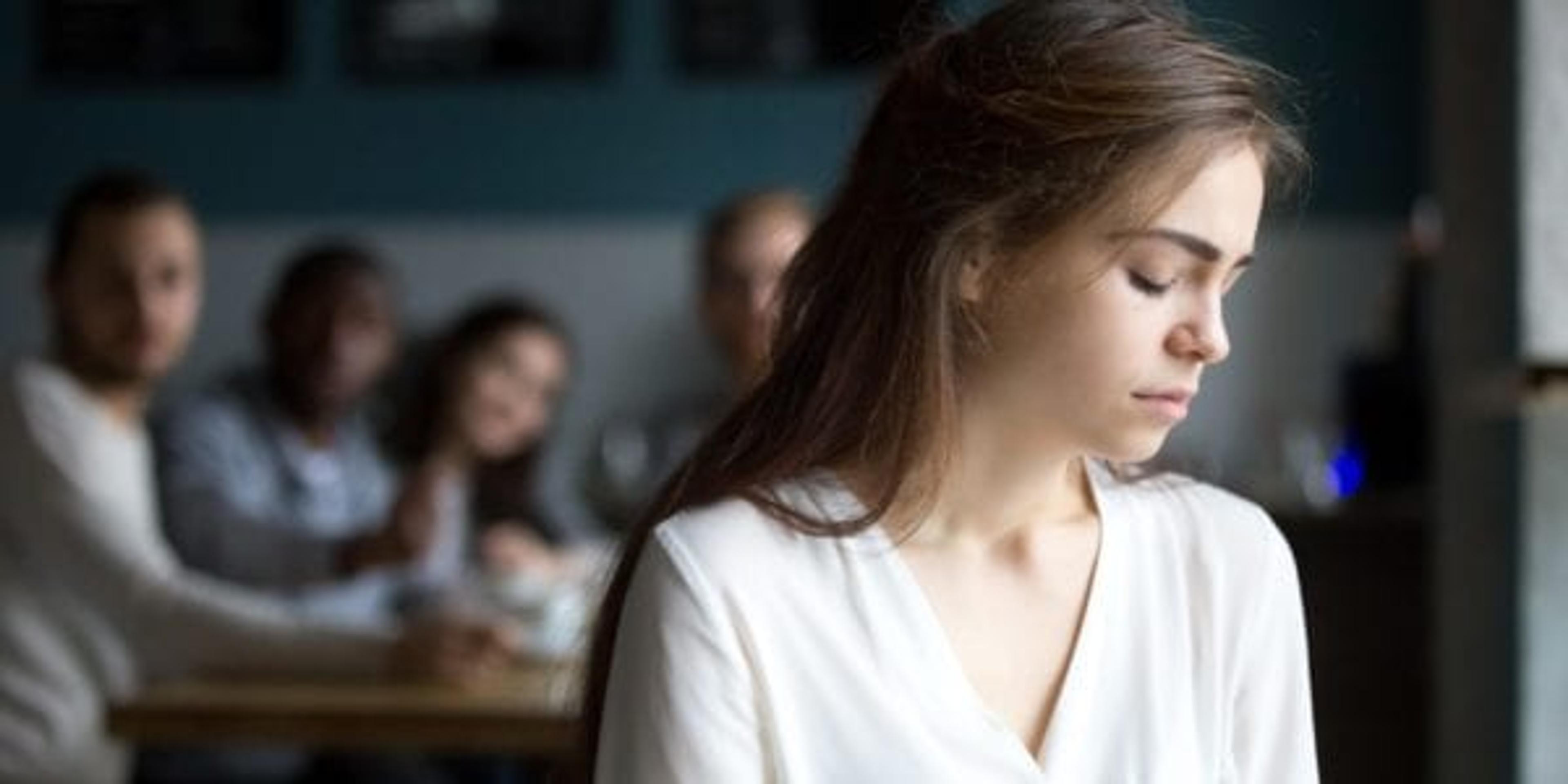 Sad woman turned away from group