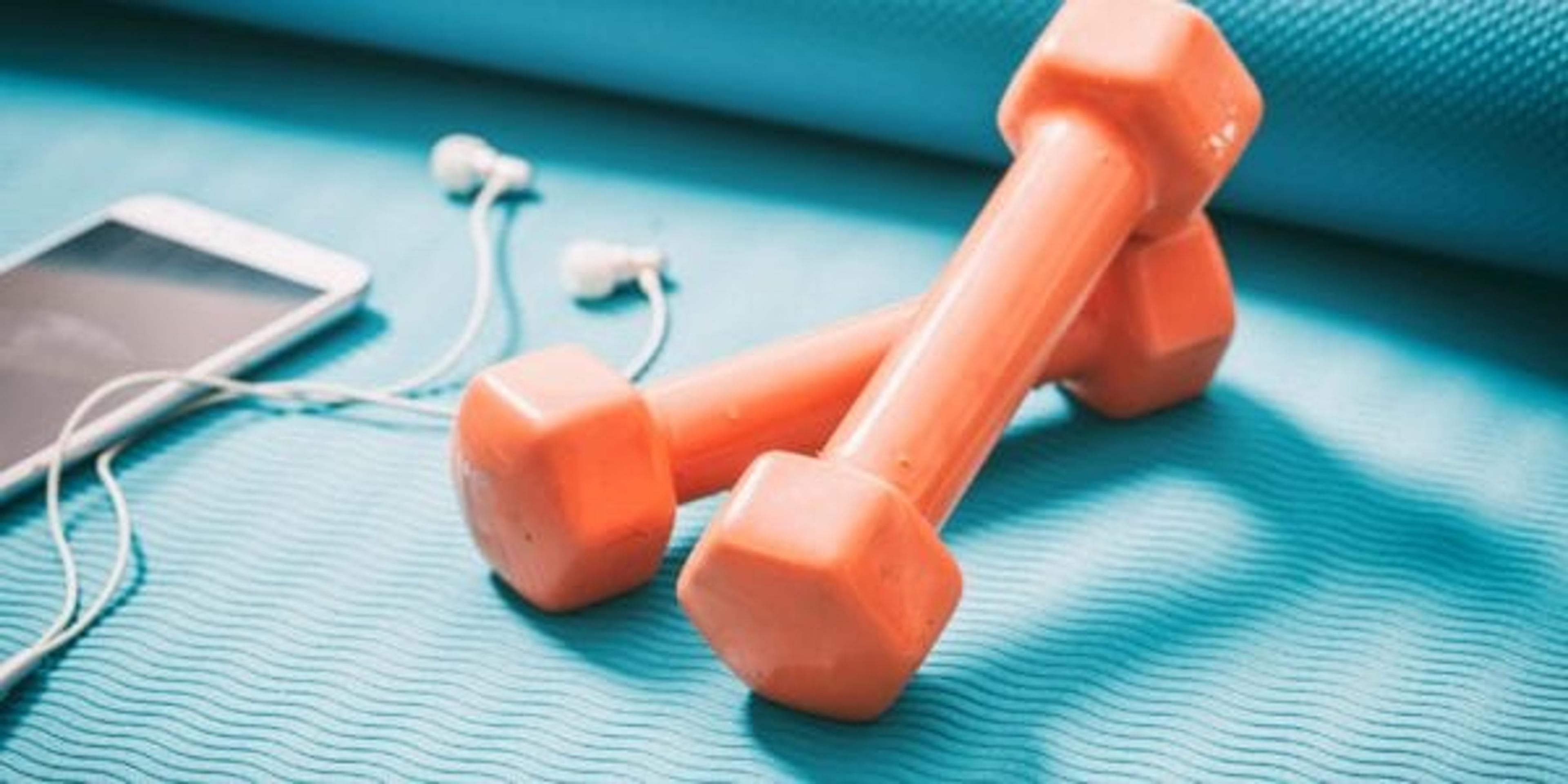 Small hand weights, yoga mat and phone with headphones