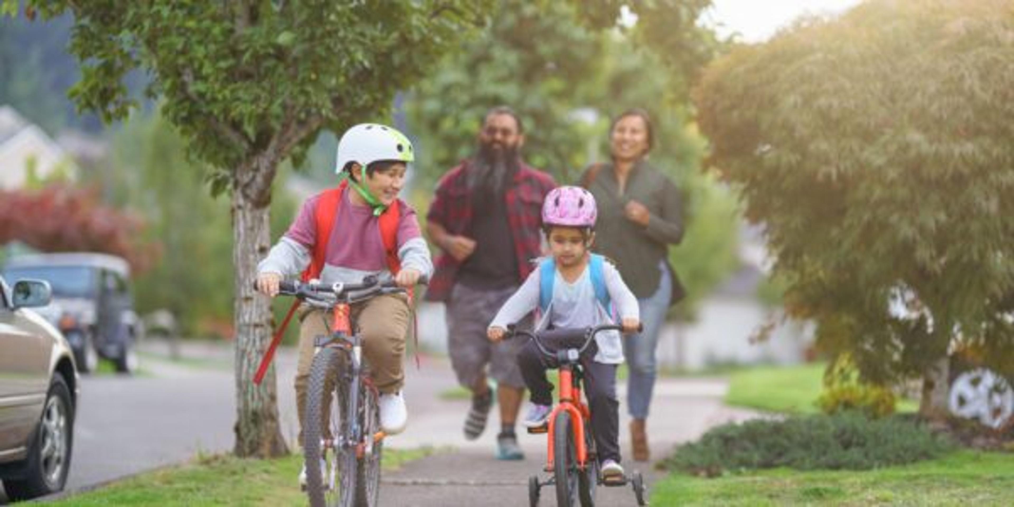 Happy Native American siblings riding their bikes to school